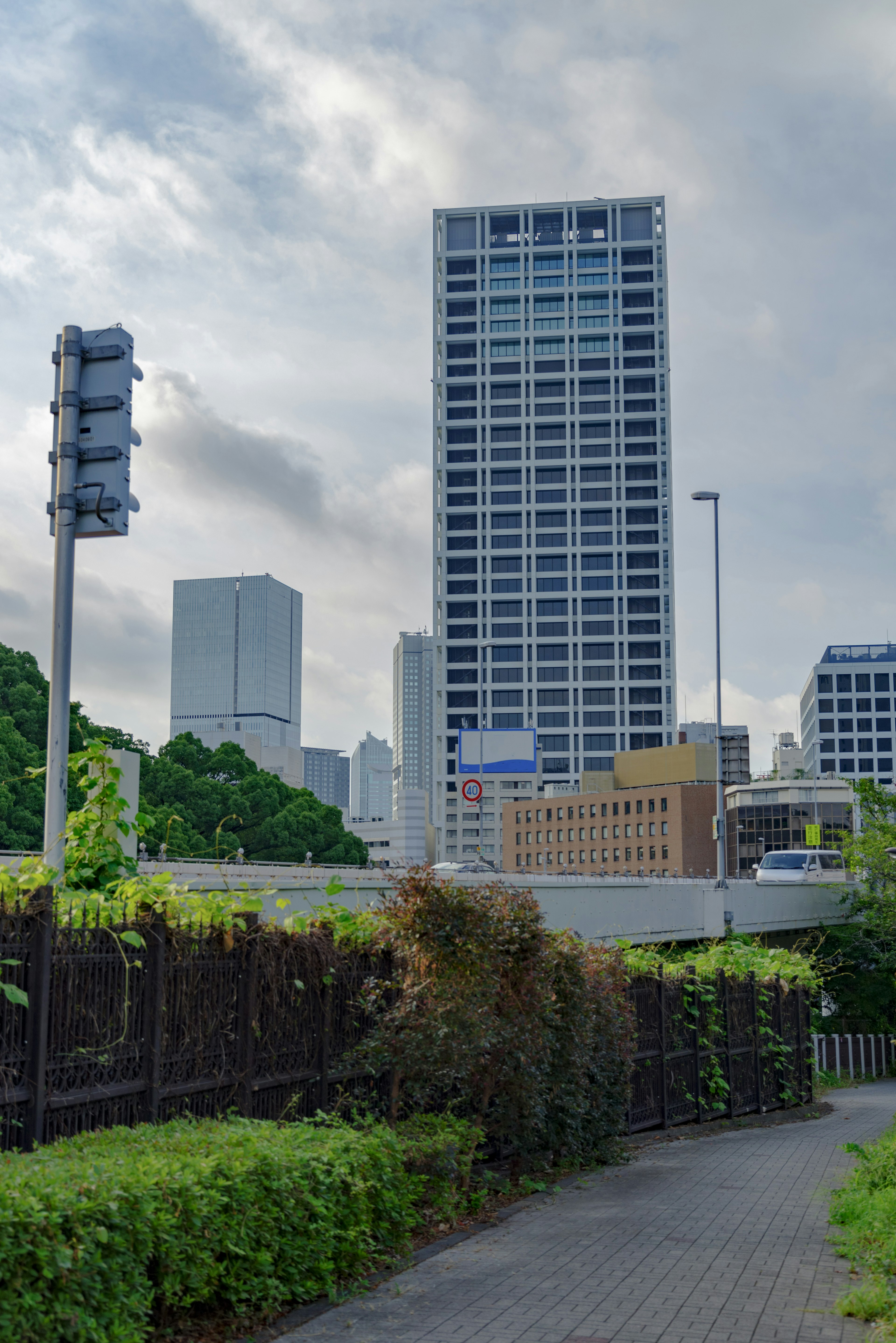 Urban landscape featuring tall buildings lush greenery and a pathway