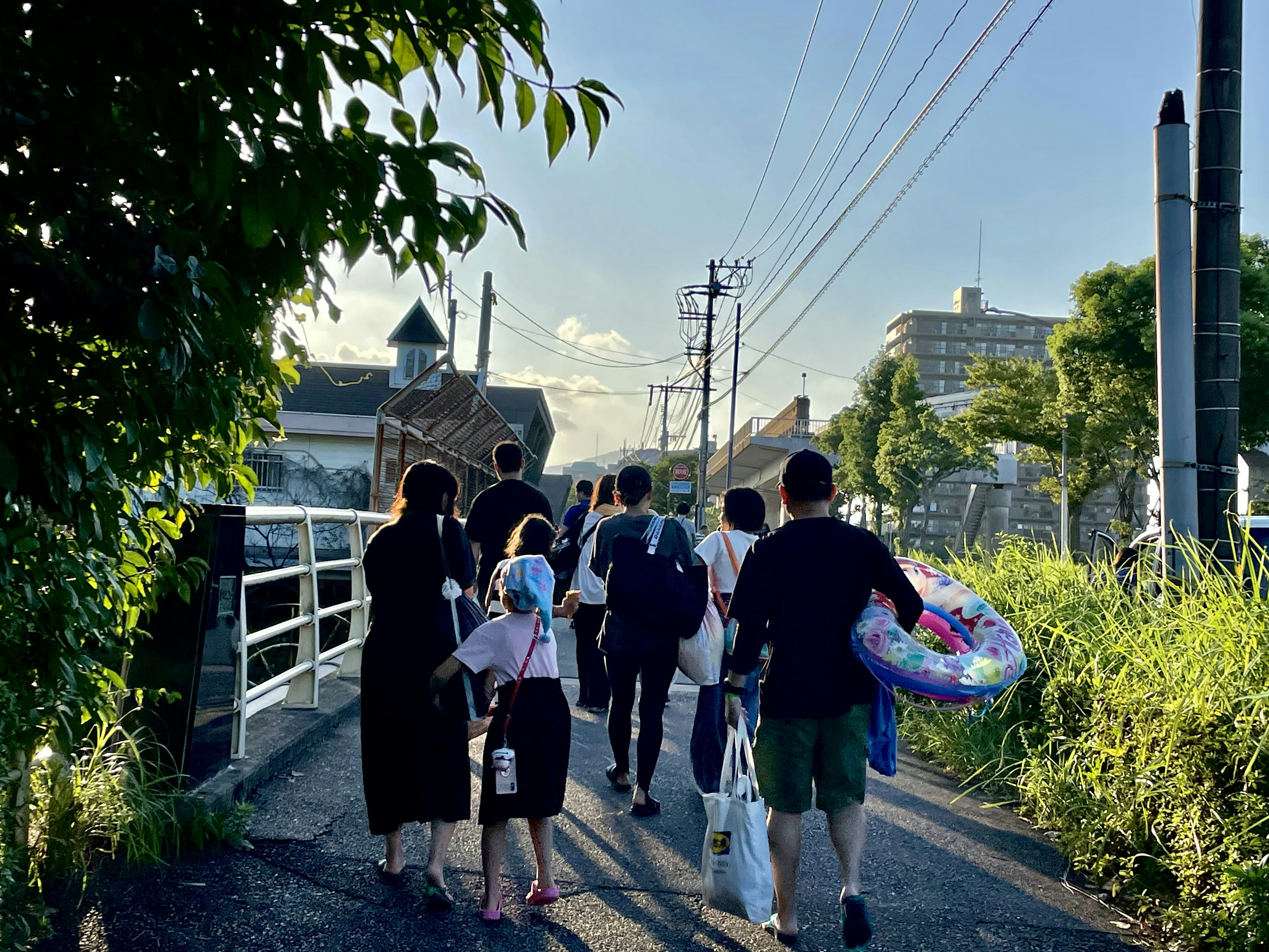 Sekelompok orang berjalan di jalur dengan jembatan di latar belakang