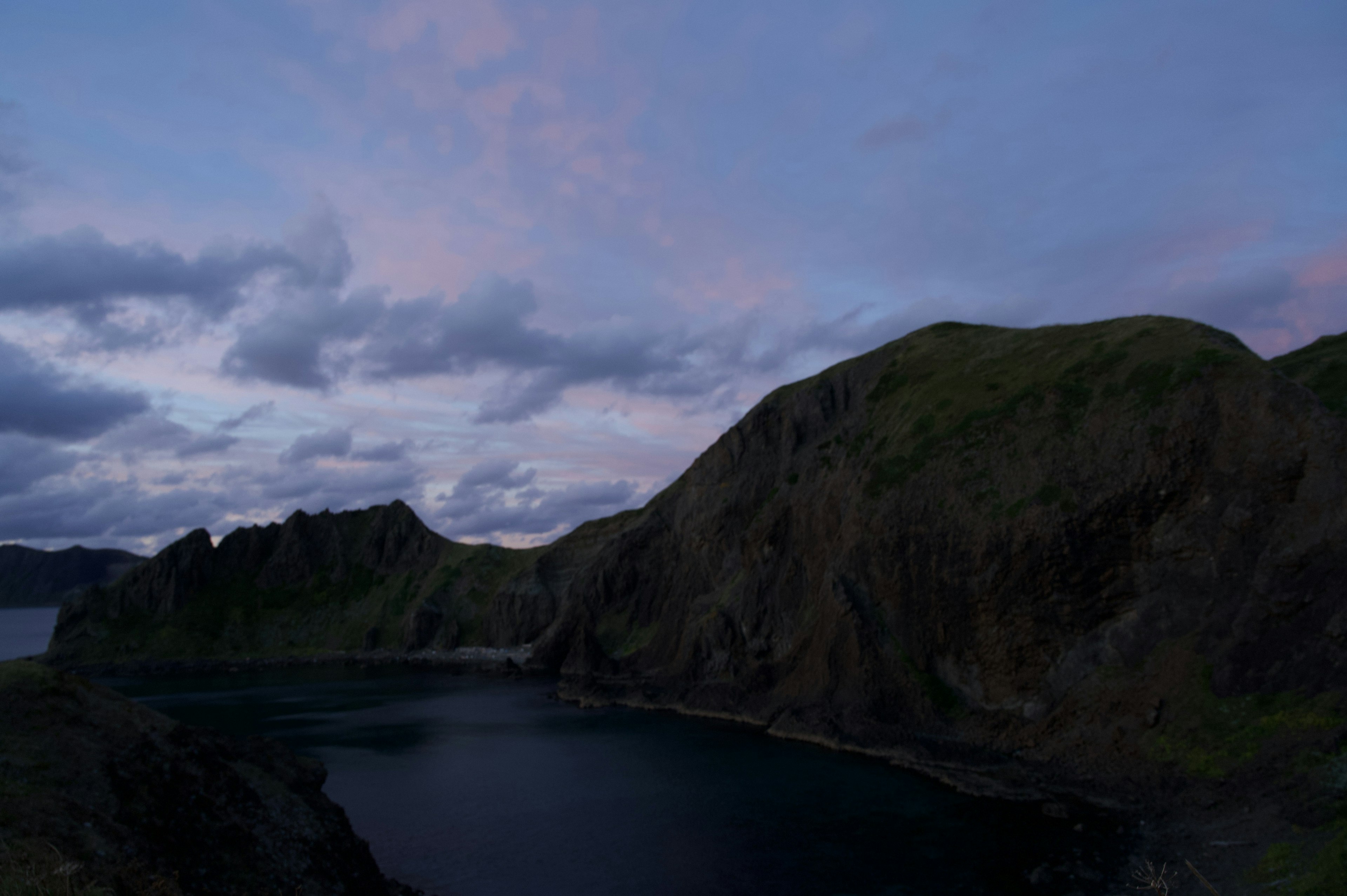 夕暮れの海と険しい山々が映える風景