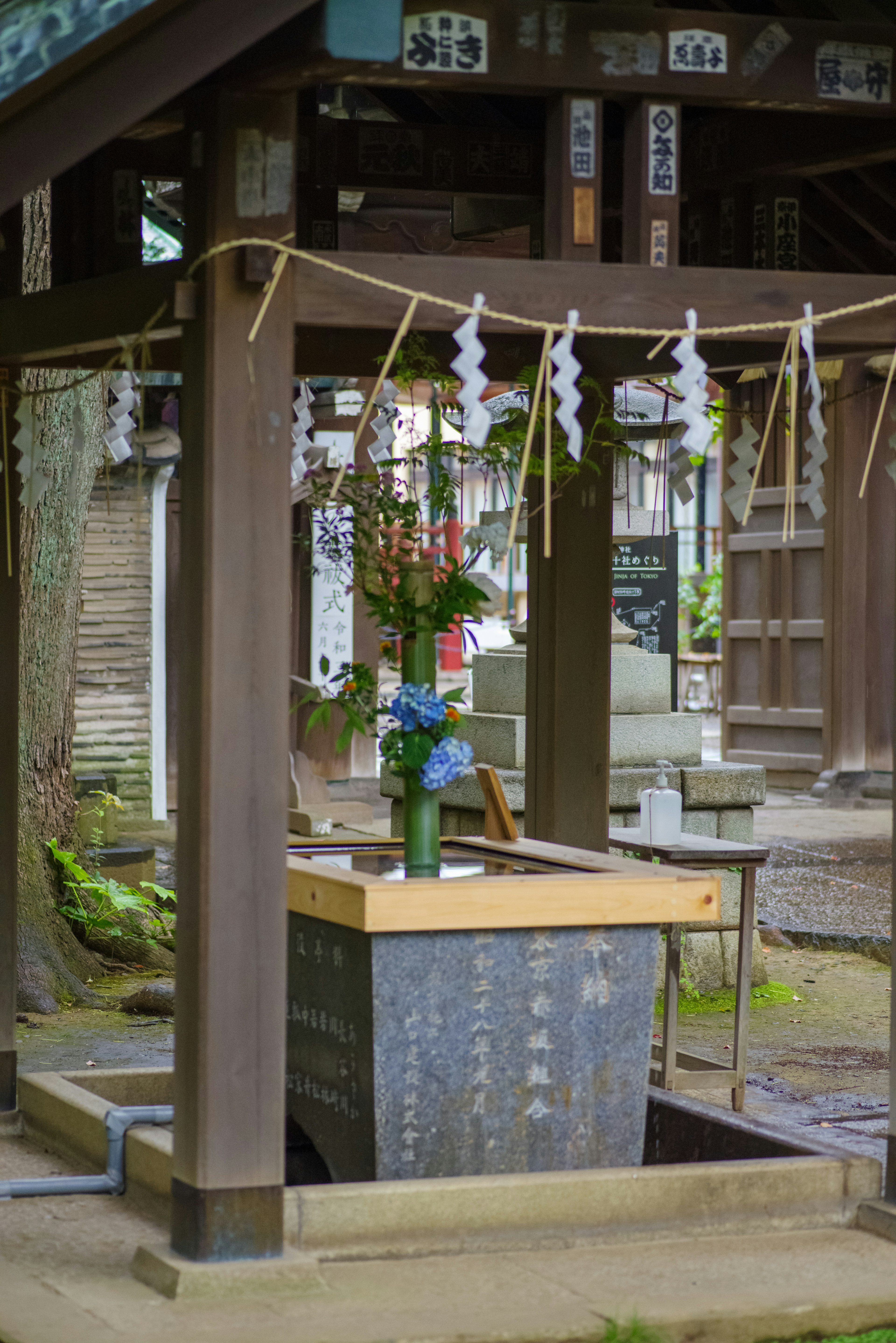 Ein Shinto-Wasserreinigungsbereich mit einer Vase voller Blumen und klarem Wasser