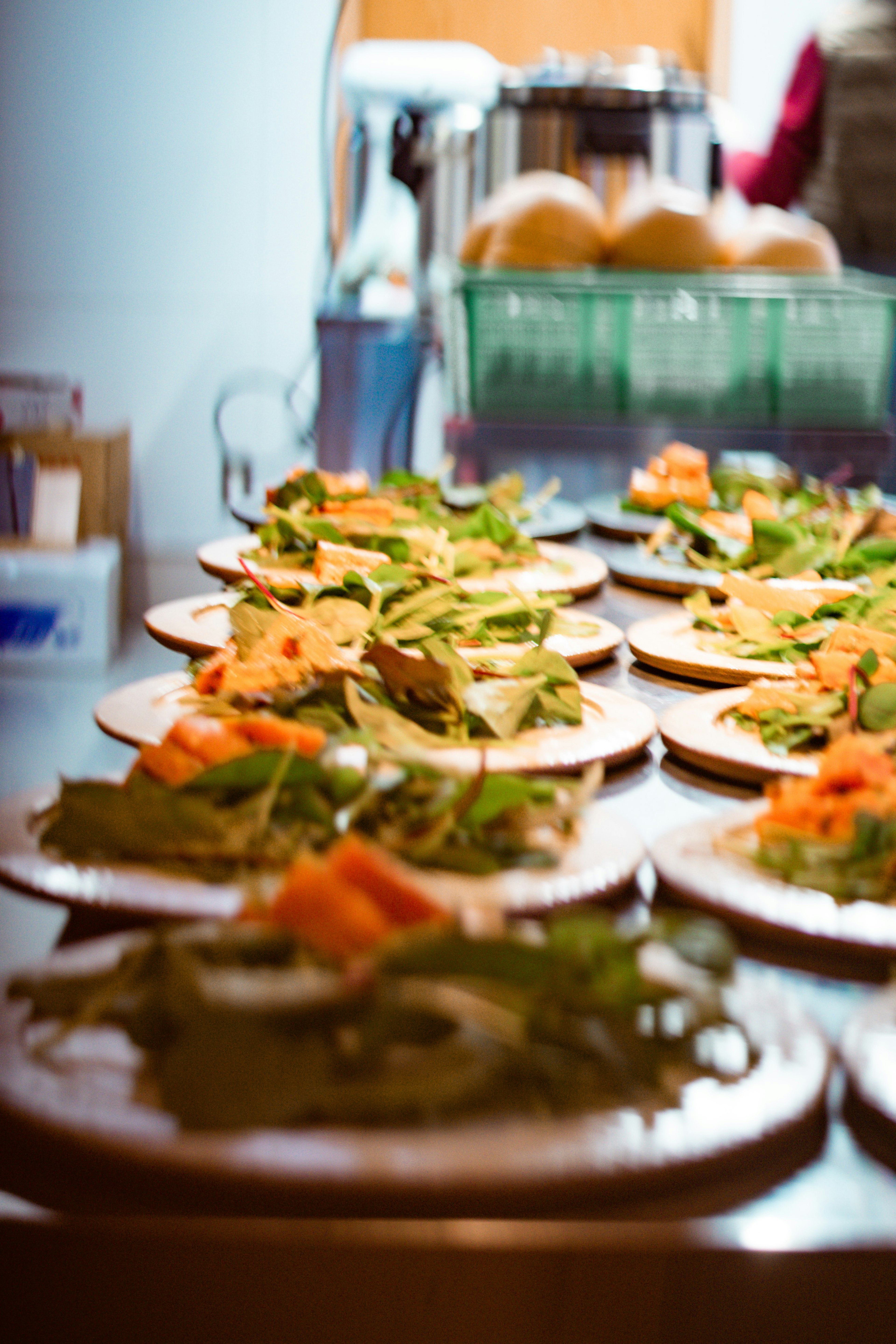 Fila de platos con ensaladas que presentan verduras frescas y coberturas naranjas