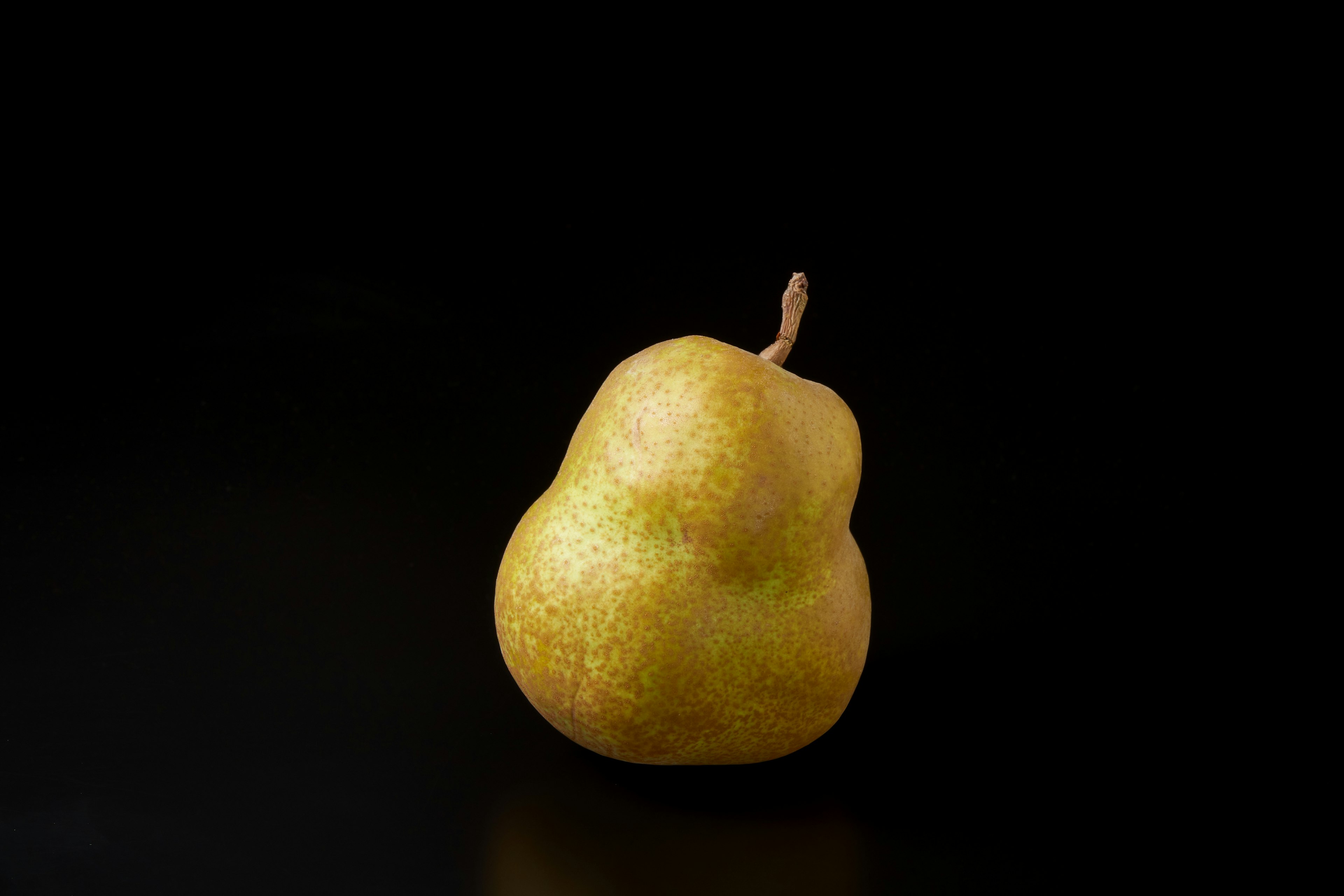 Yellow pear placed on a black background