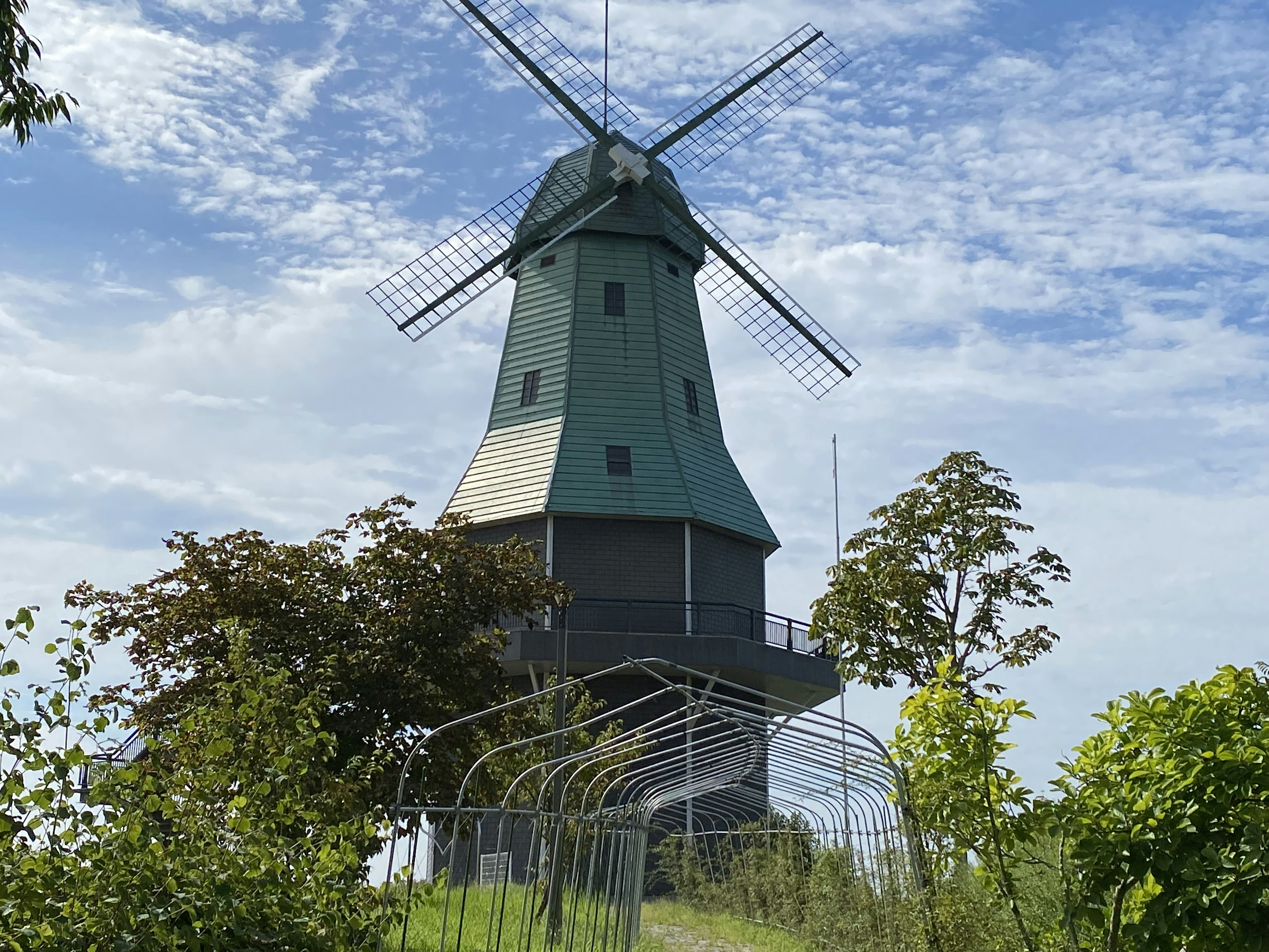 Moulin à vent avec un toit vert sous un ciel bleu