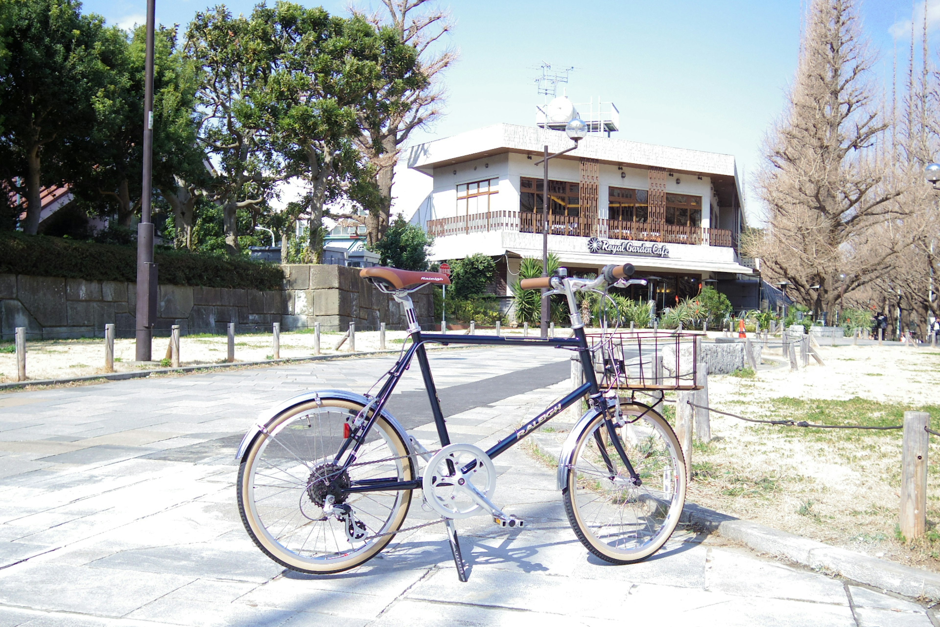 青い自転車が公園の道に立っている風景と背景の建物