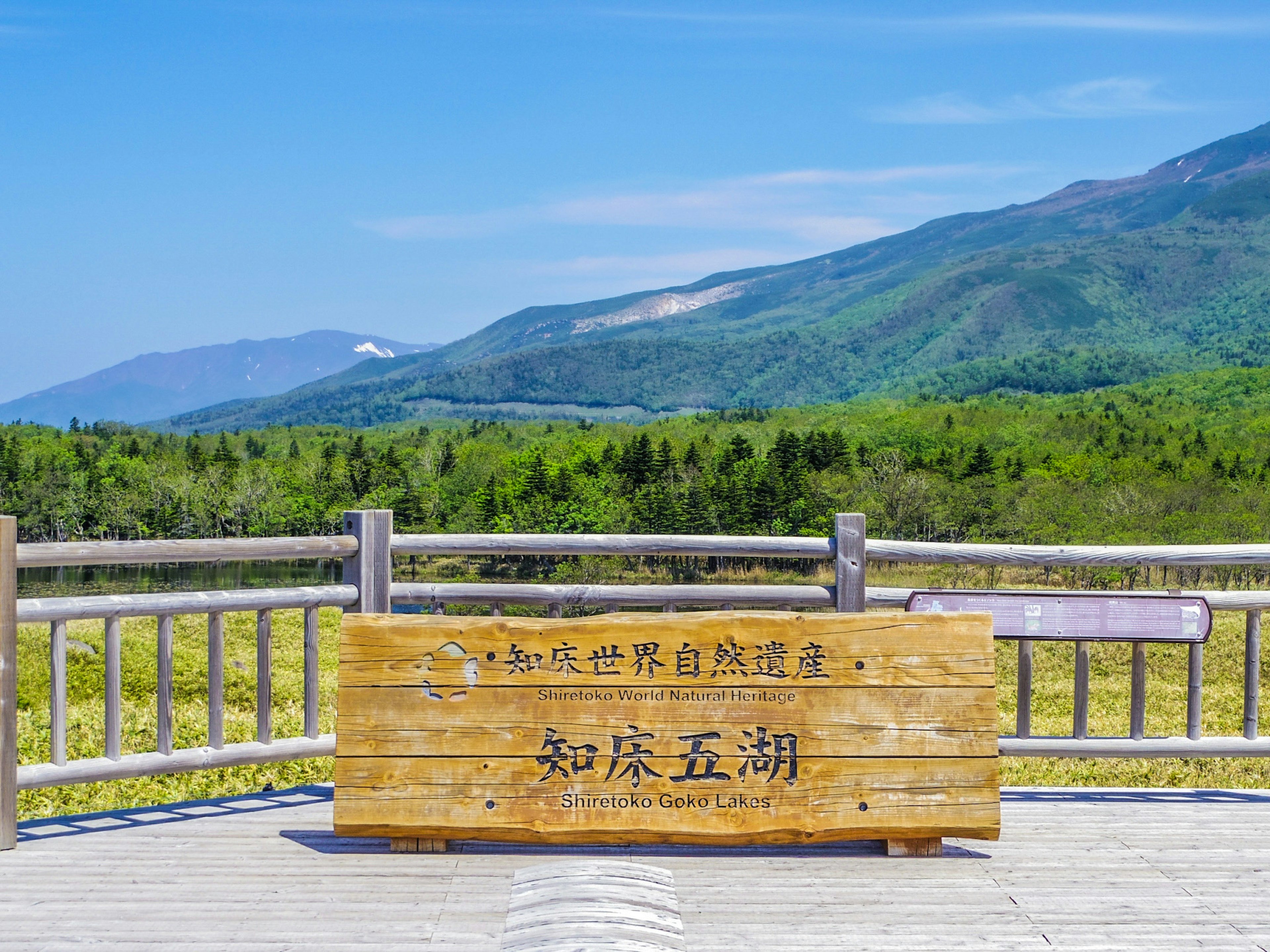 Papan kayu di tempat wisata dengan pemandangan panorama gunung