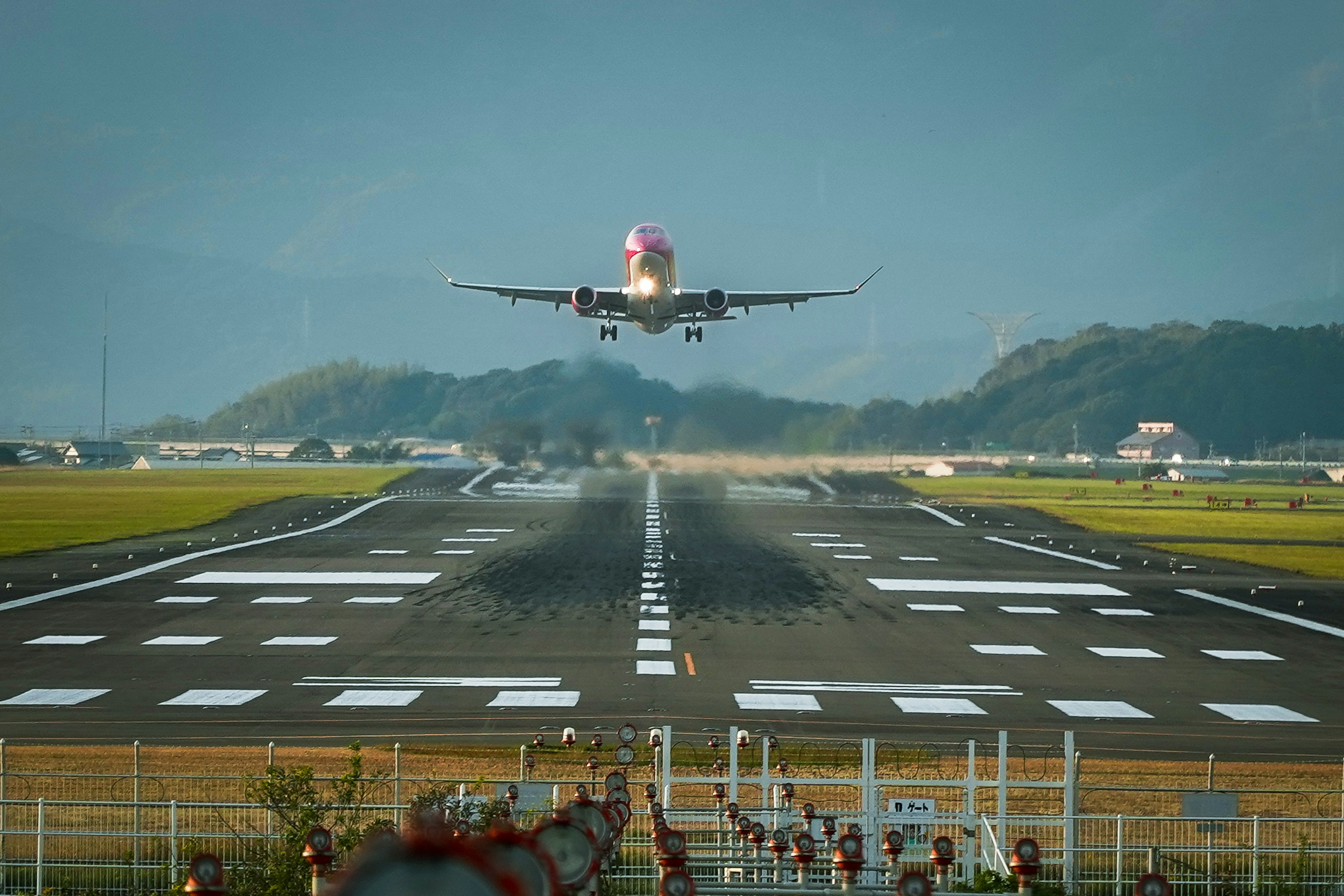 飛行機が滑走路に着陸するシーン 空港の背景と山々が見える