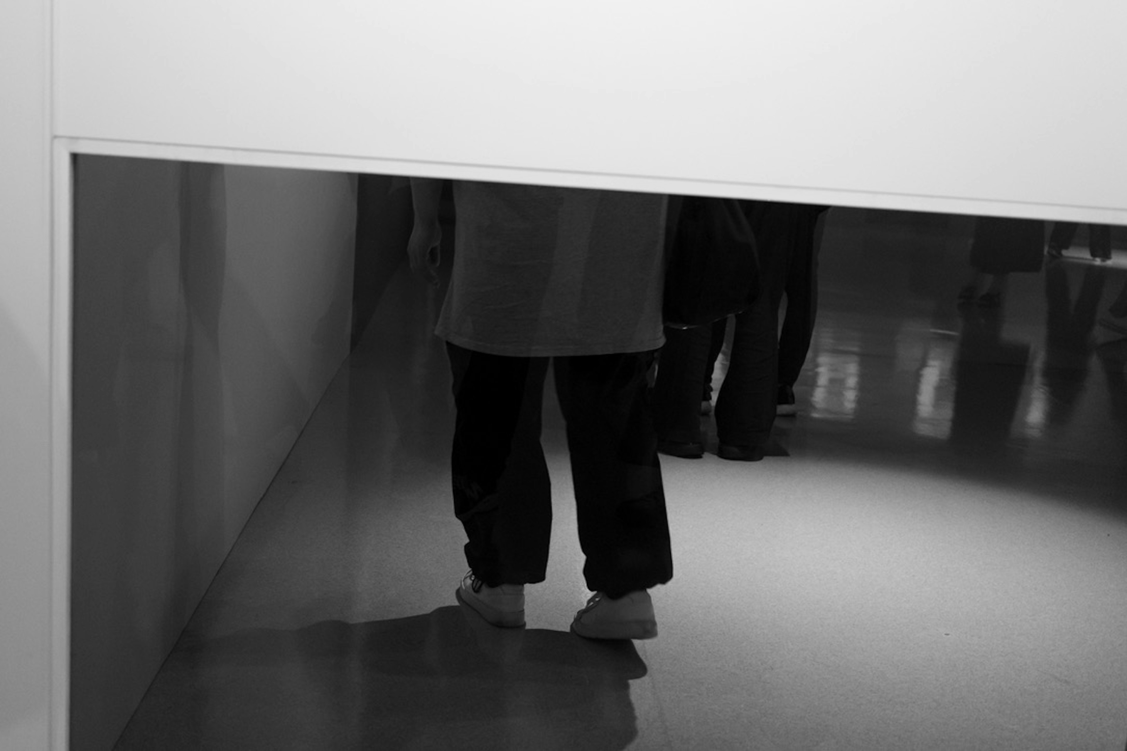 Réflexion des pieds d'une personne dans un espace en noir et blanc