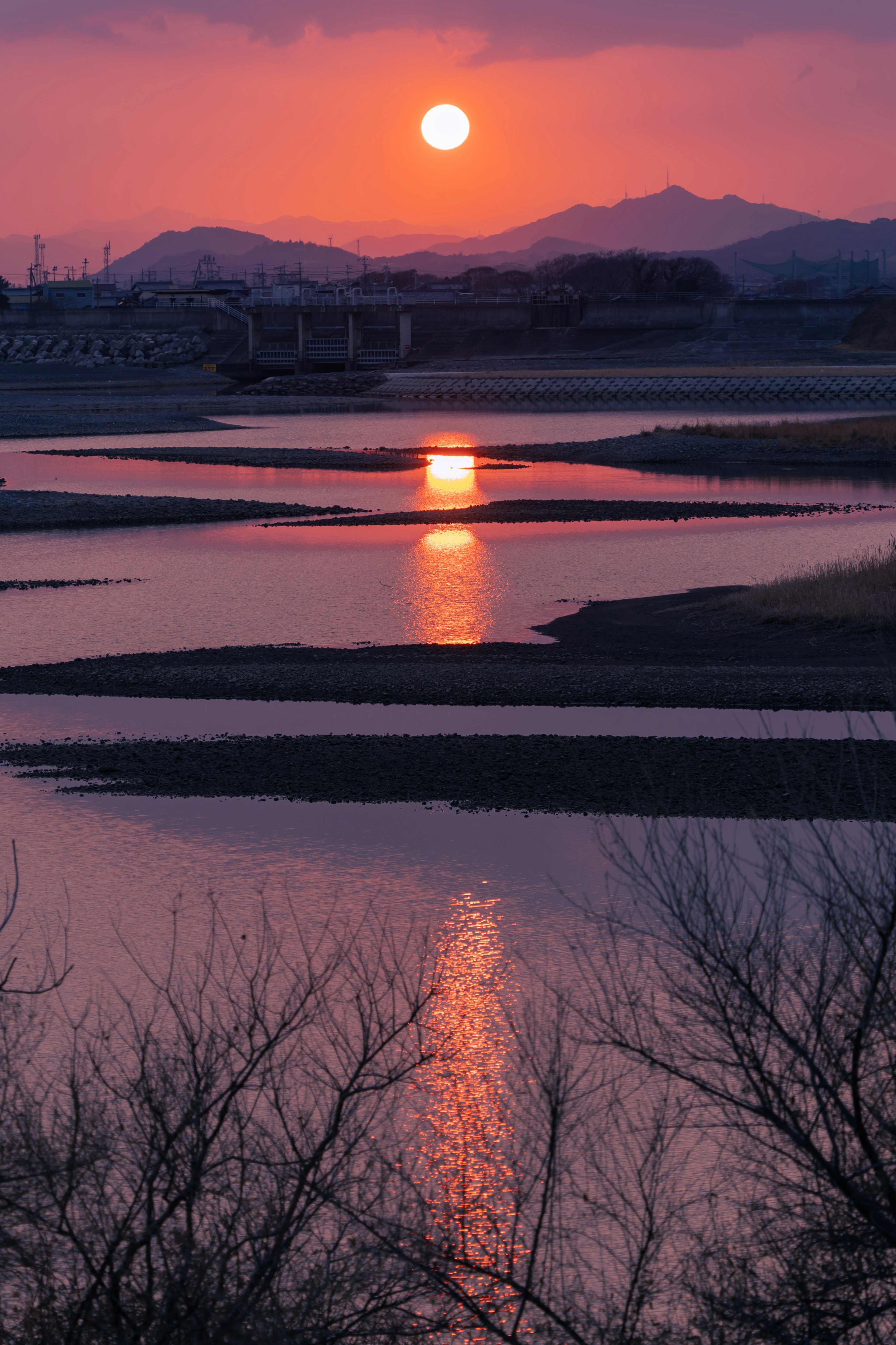 Coucher de soleil magnifique sur une rivière avec des montagnes en silhouette