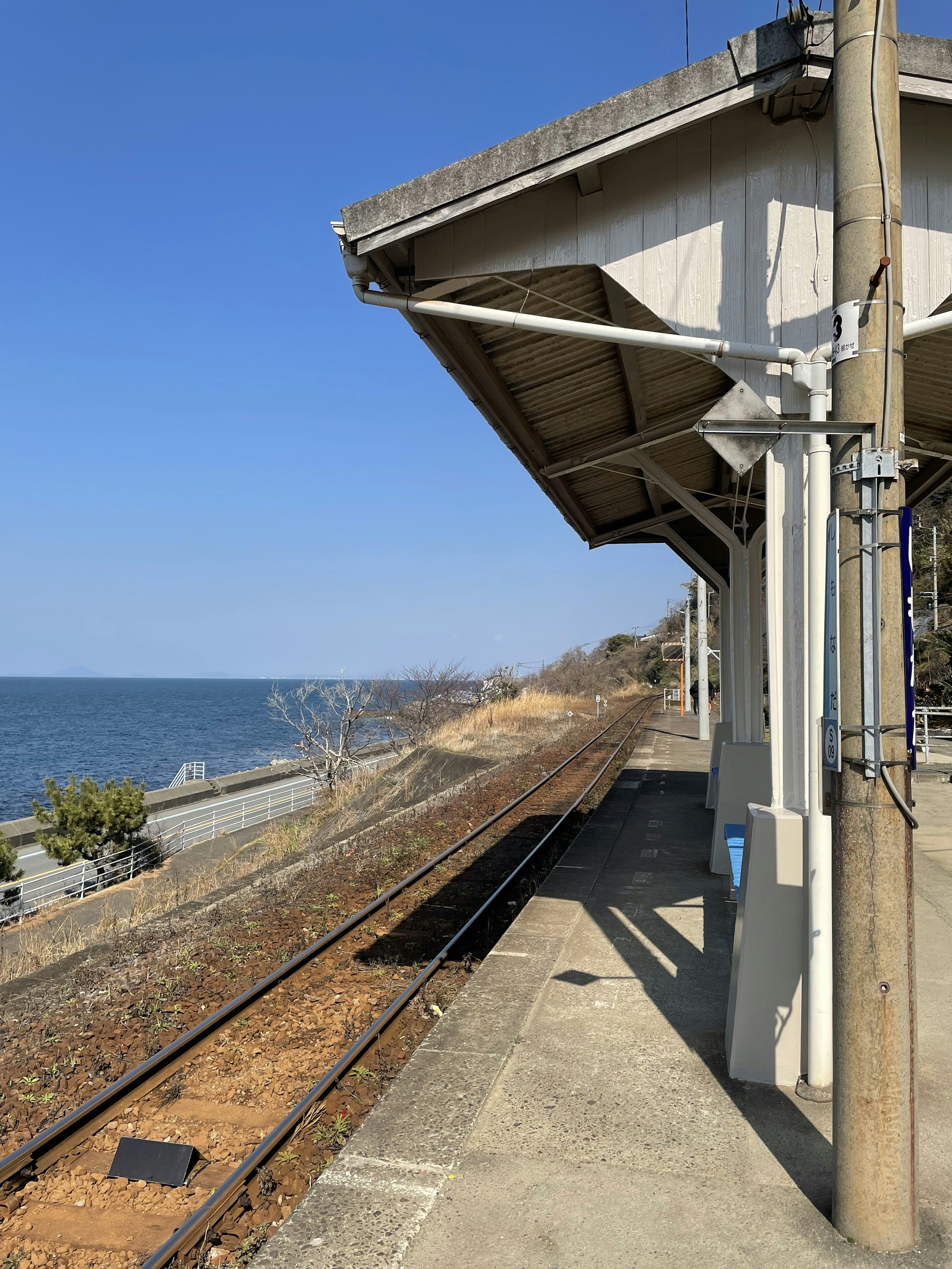 海沿いの駅のプラットフォームと線路の風景