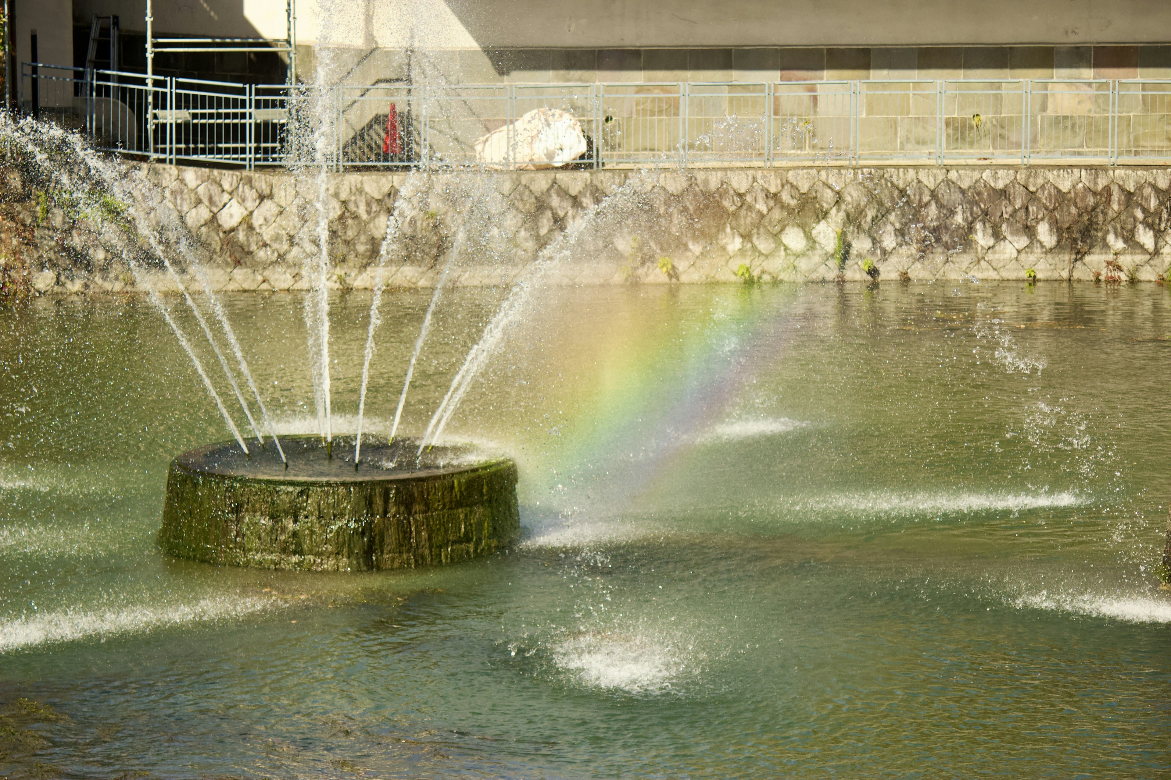 Fontaine créant un arc-en-ciel au bord de l'eau