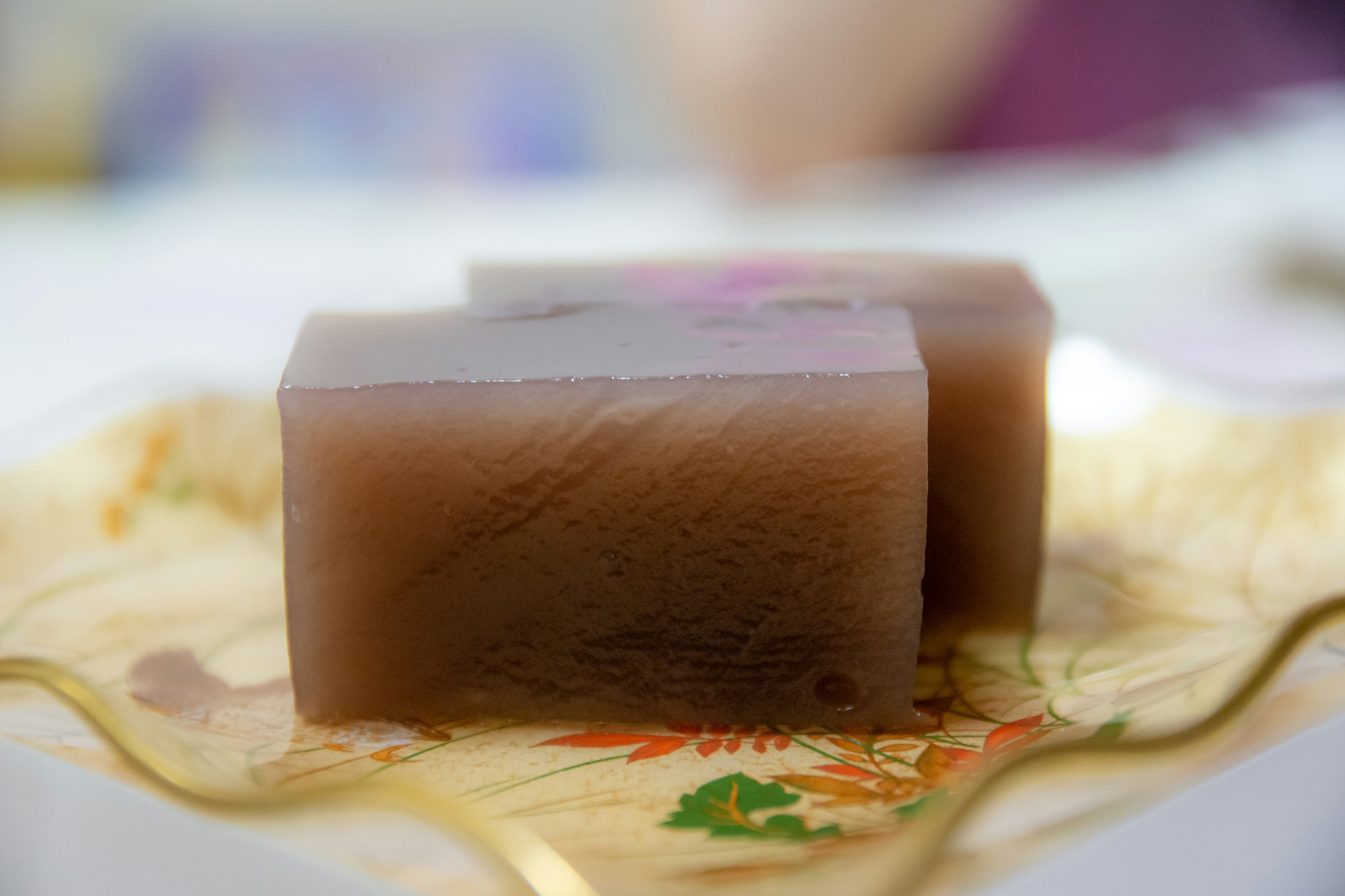 Brown jelly dessert placed on a golden plate