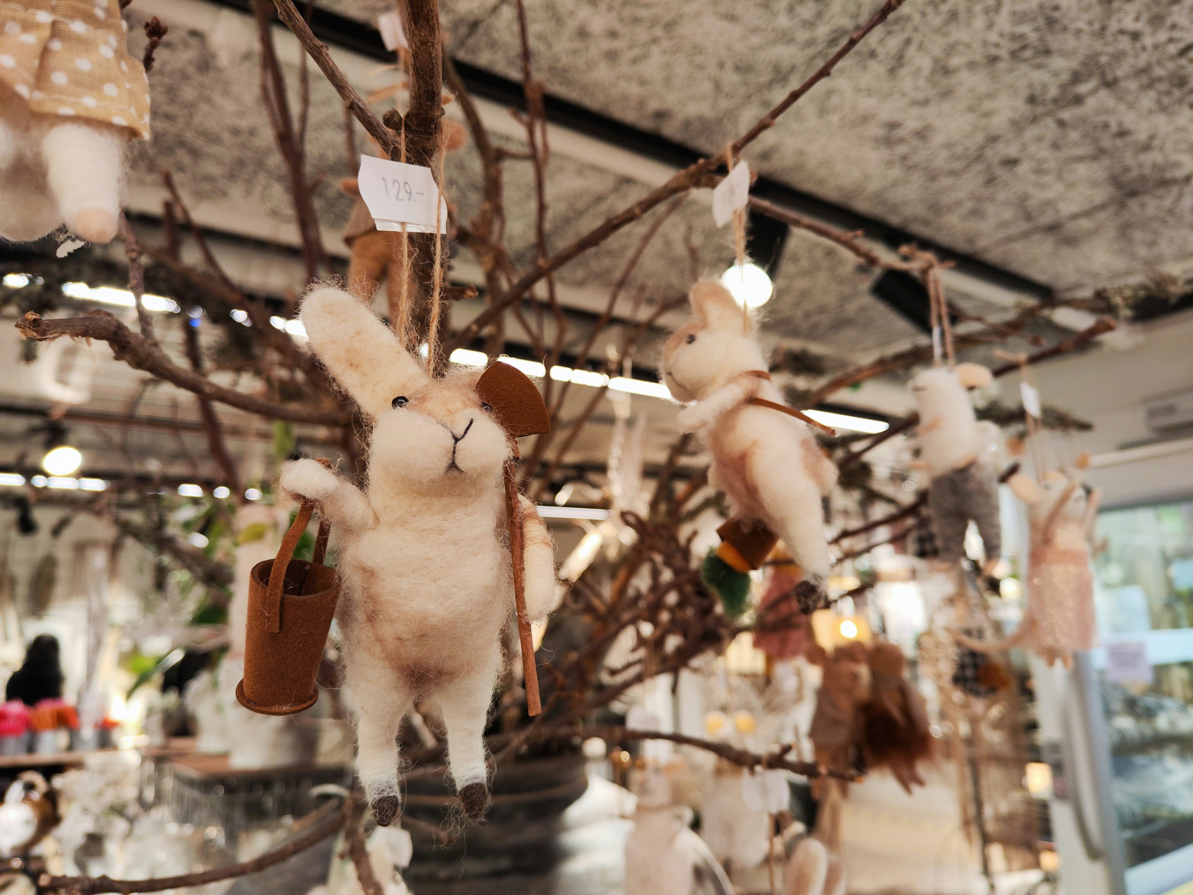 Décorations de lapins mignons suspendues à des branches d'arbre avec un fond naturel