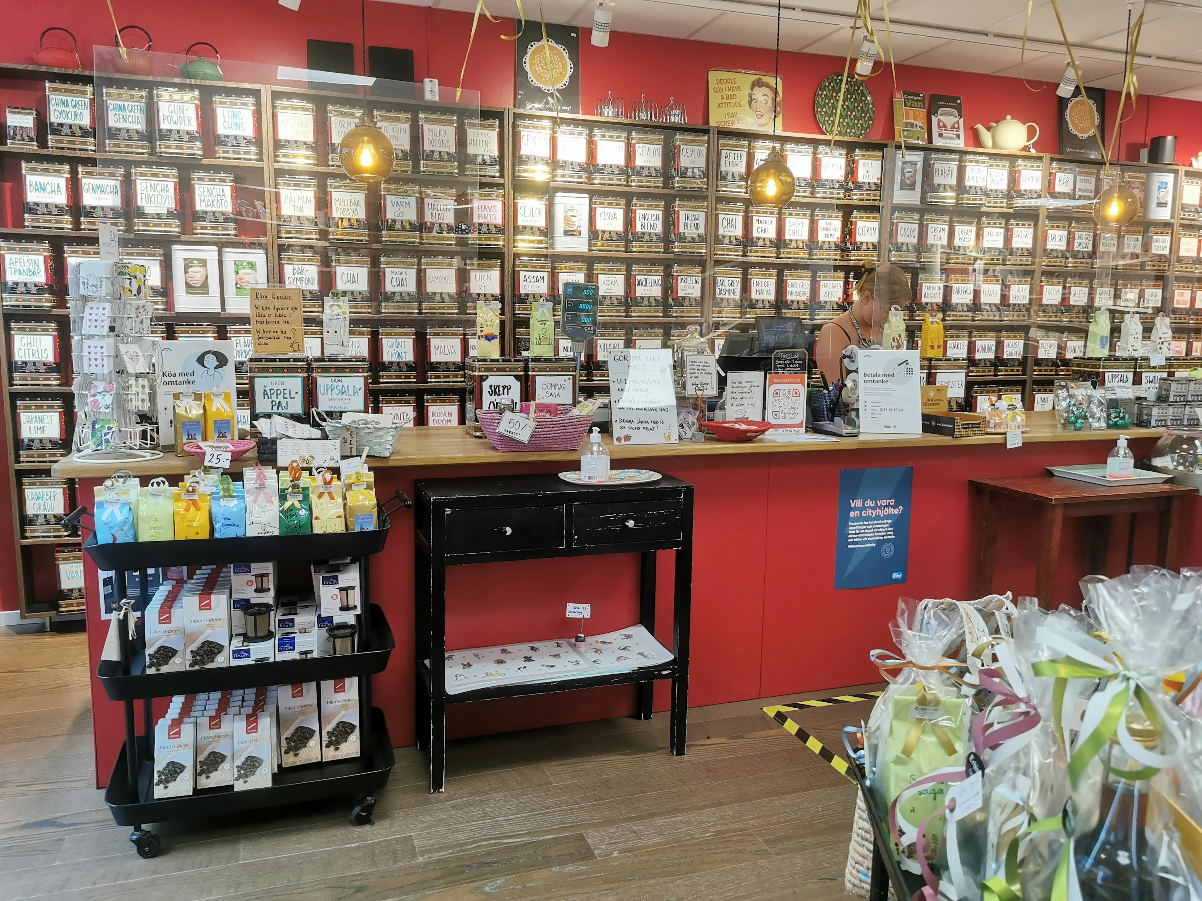 Interior of a shop with a red wall displaying frames and products at the counter