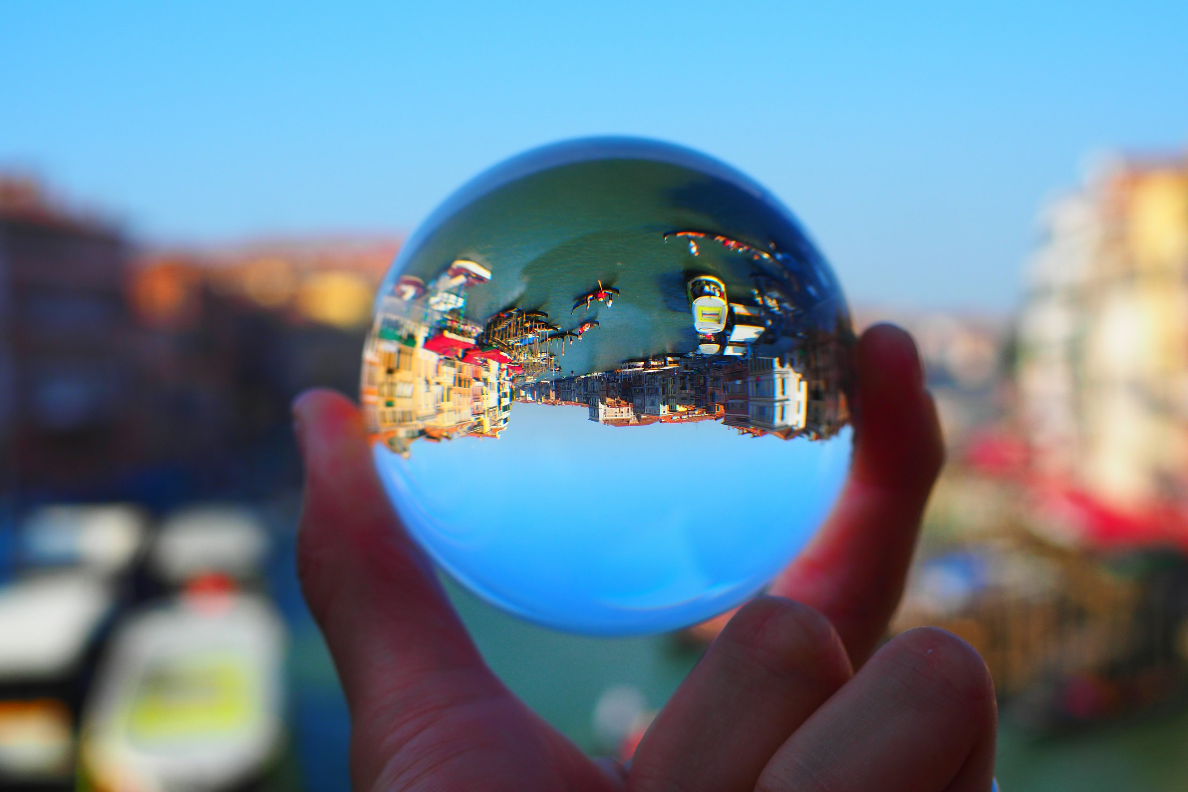 Un hermoso paisaje reflejado en una bola de cristal sostenida en la mano