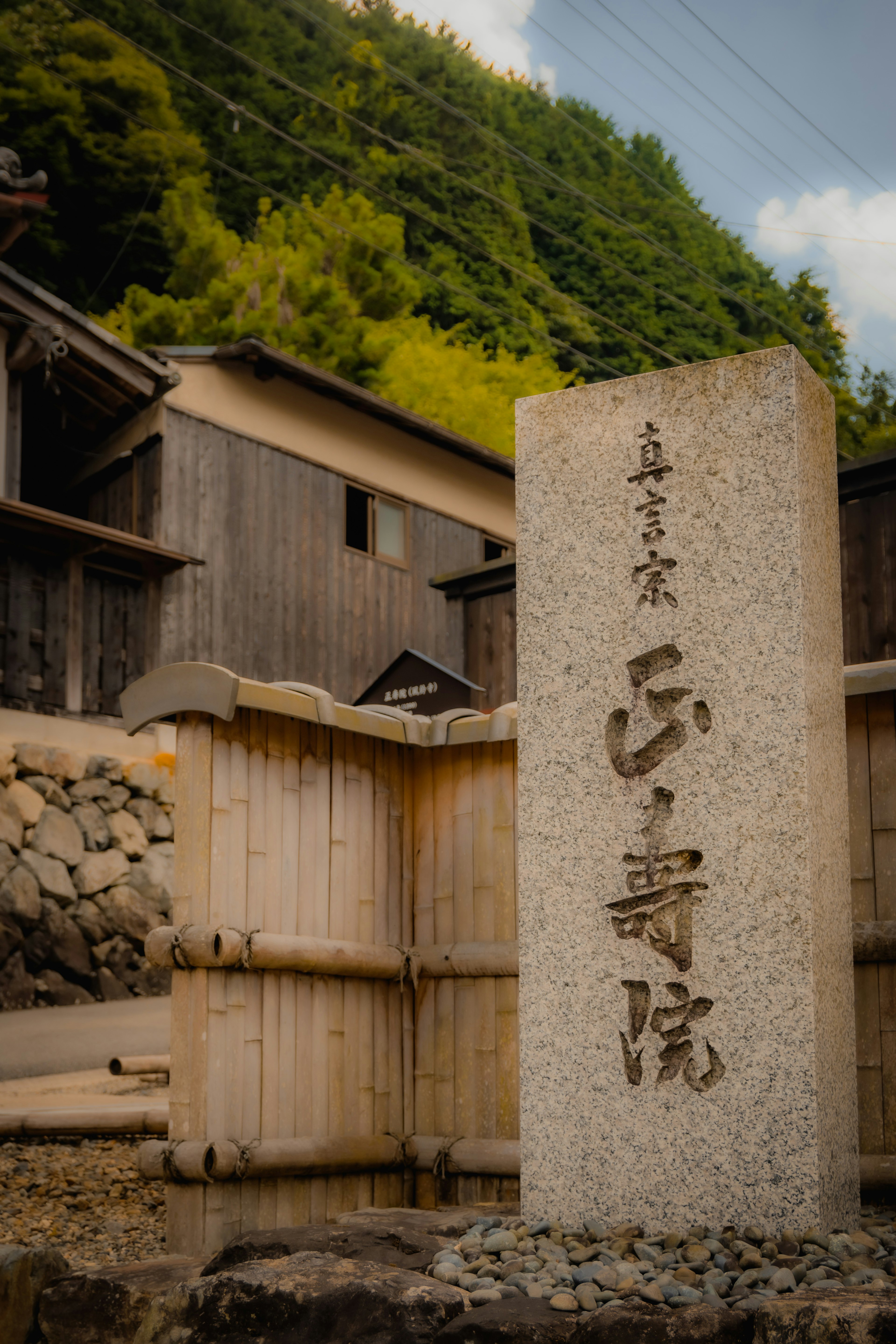 Stone monument with Japanese characters surrounded by greenery