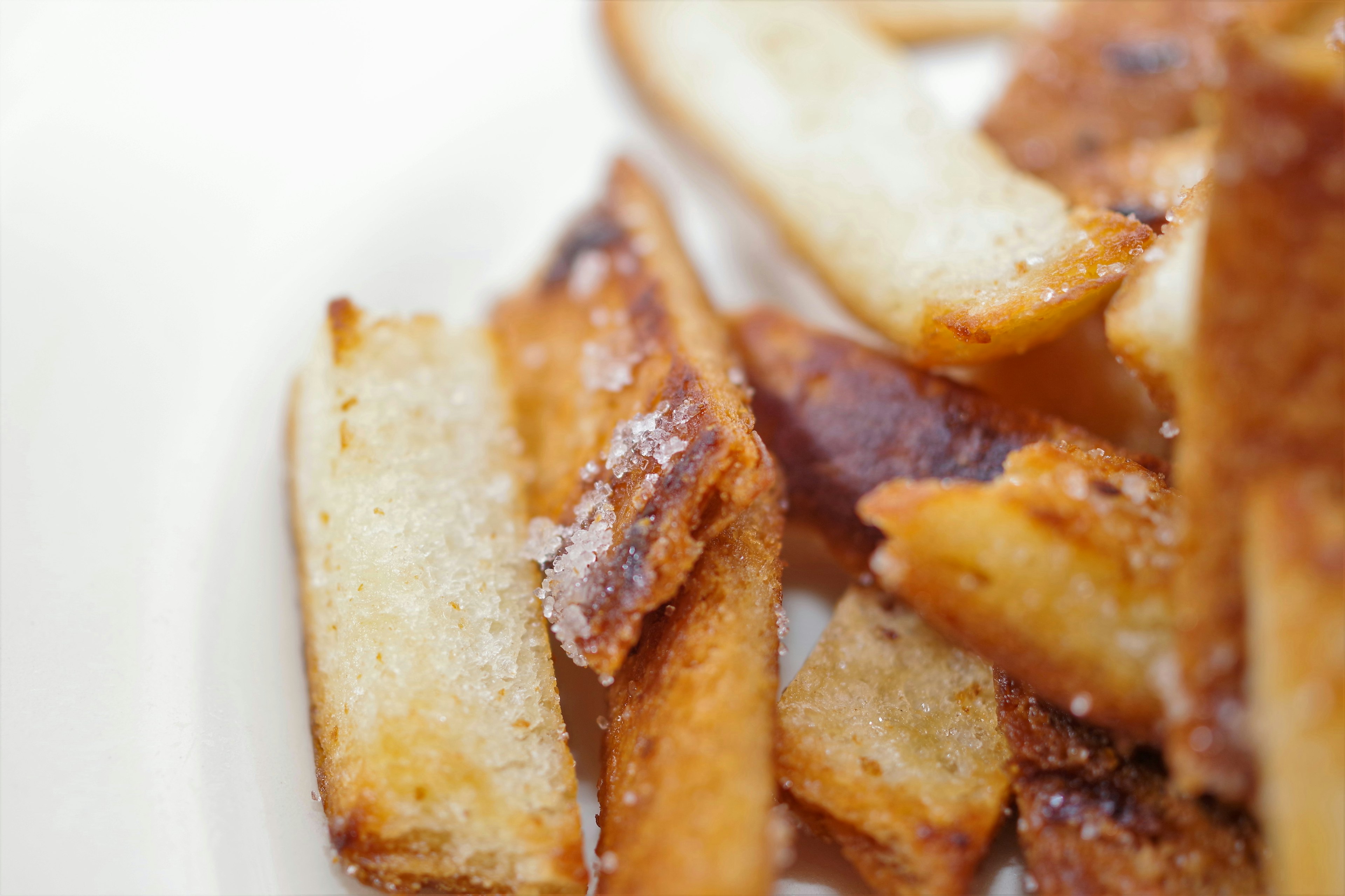 Close-up photo of fried potato wedges featuring crispy texture and golden color