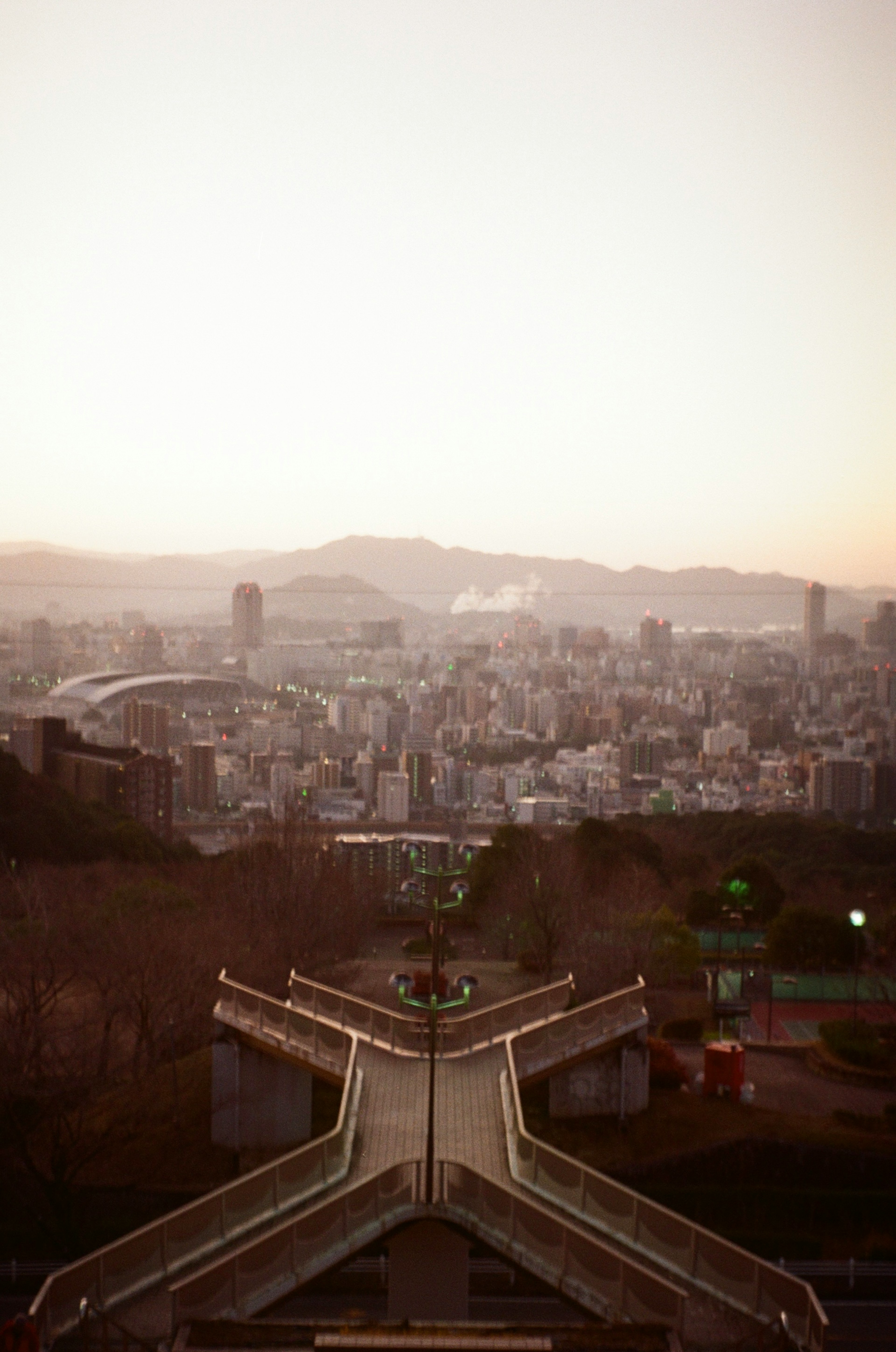 Cityscape at dusk with mountains in the background