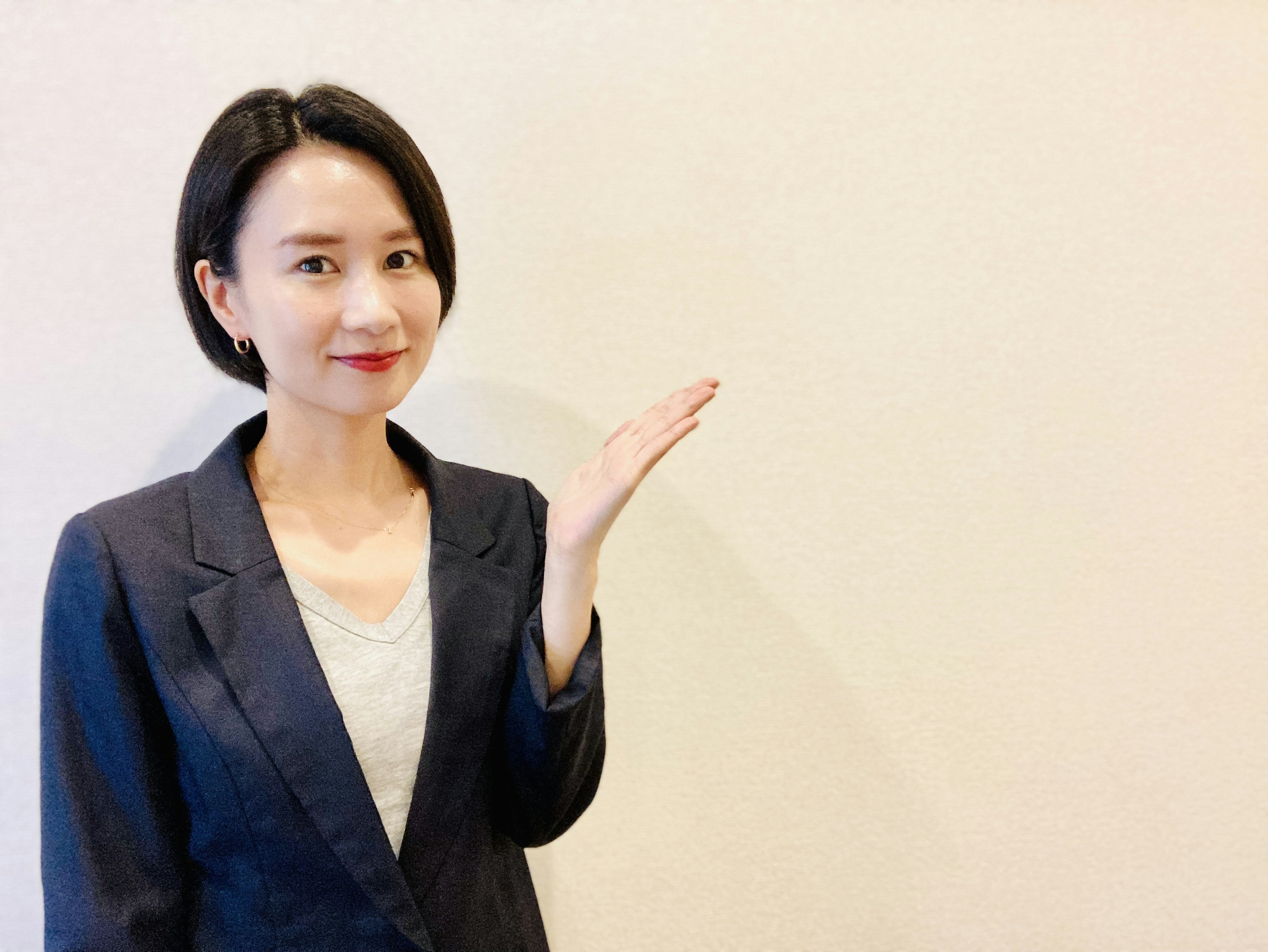 A woman in a business suit extending her hand