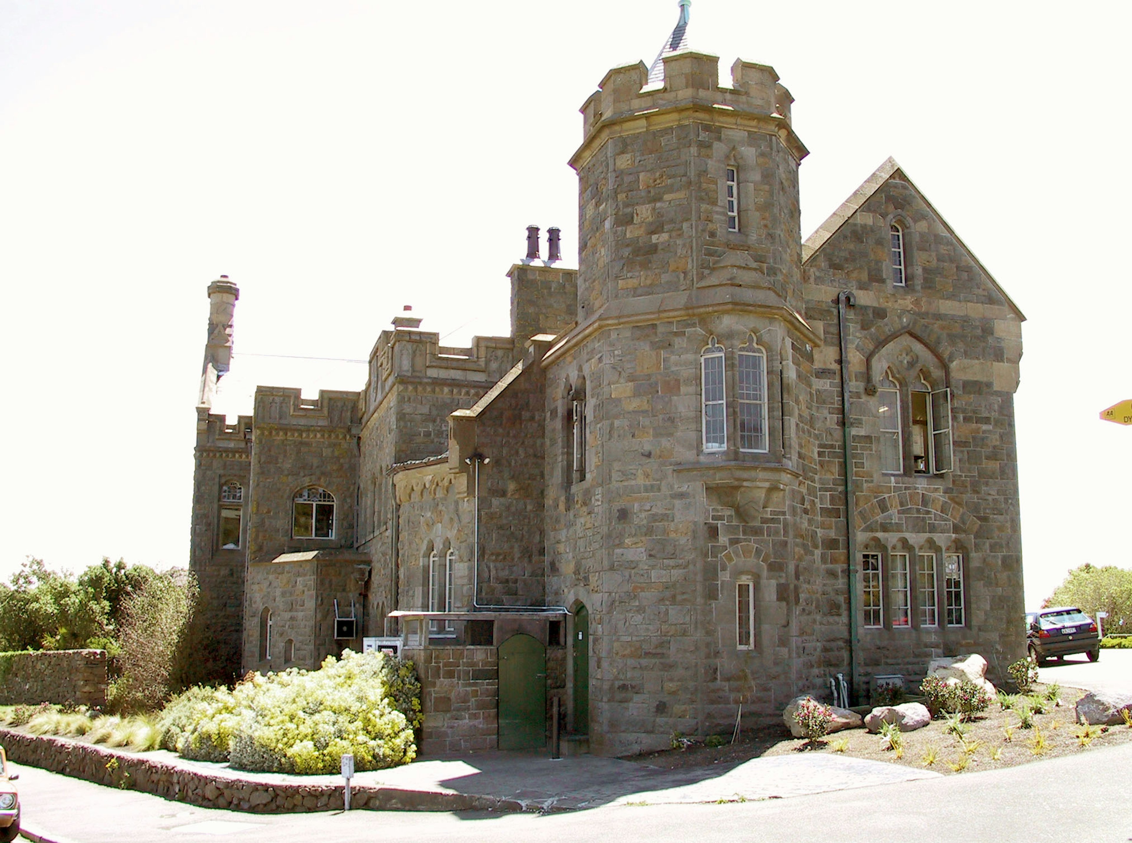 Old stone castle-like building surrounded by green plants