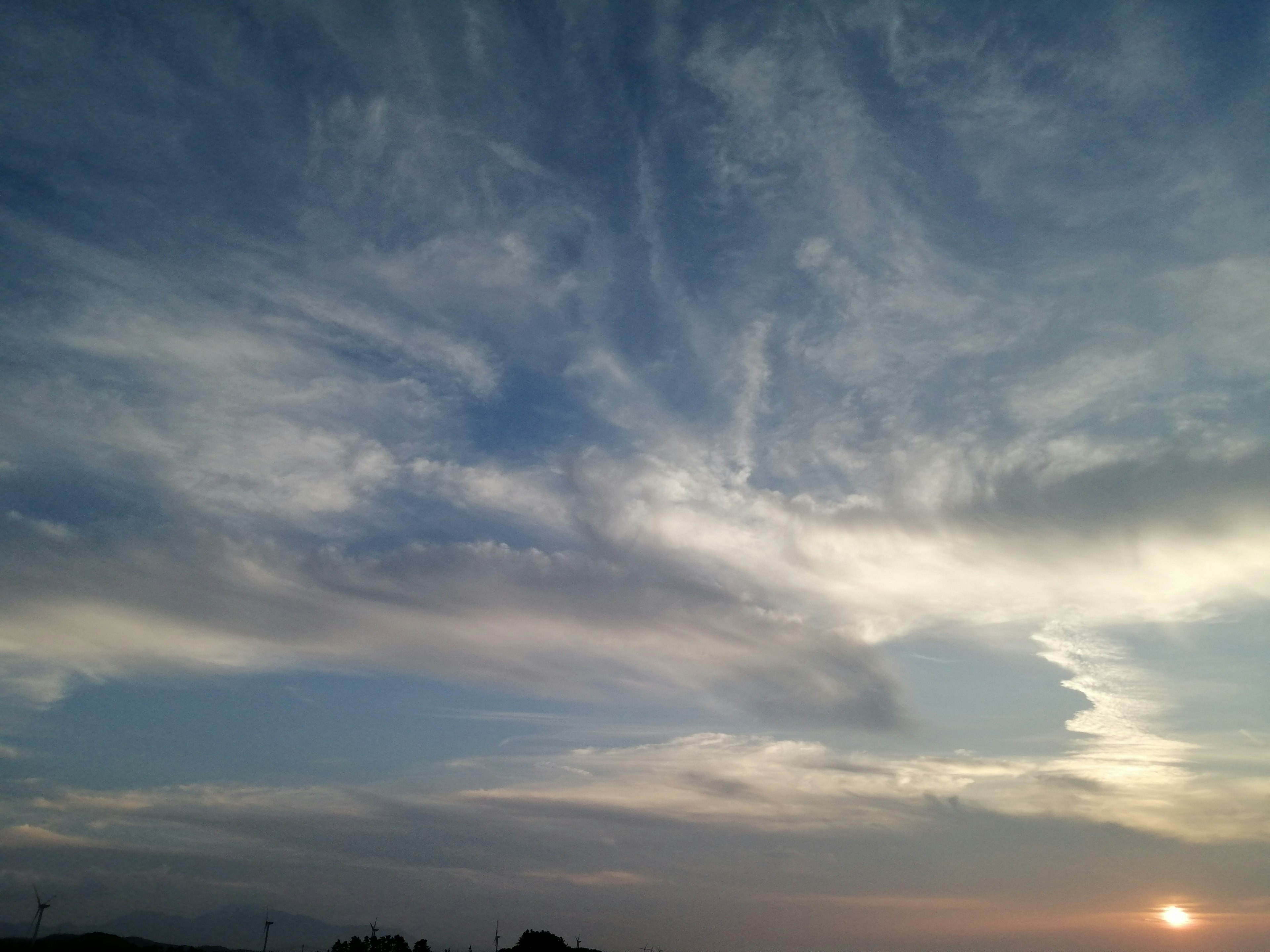 Langit biru dengan awan putih dan matahari terbenam yang indah