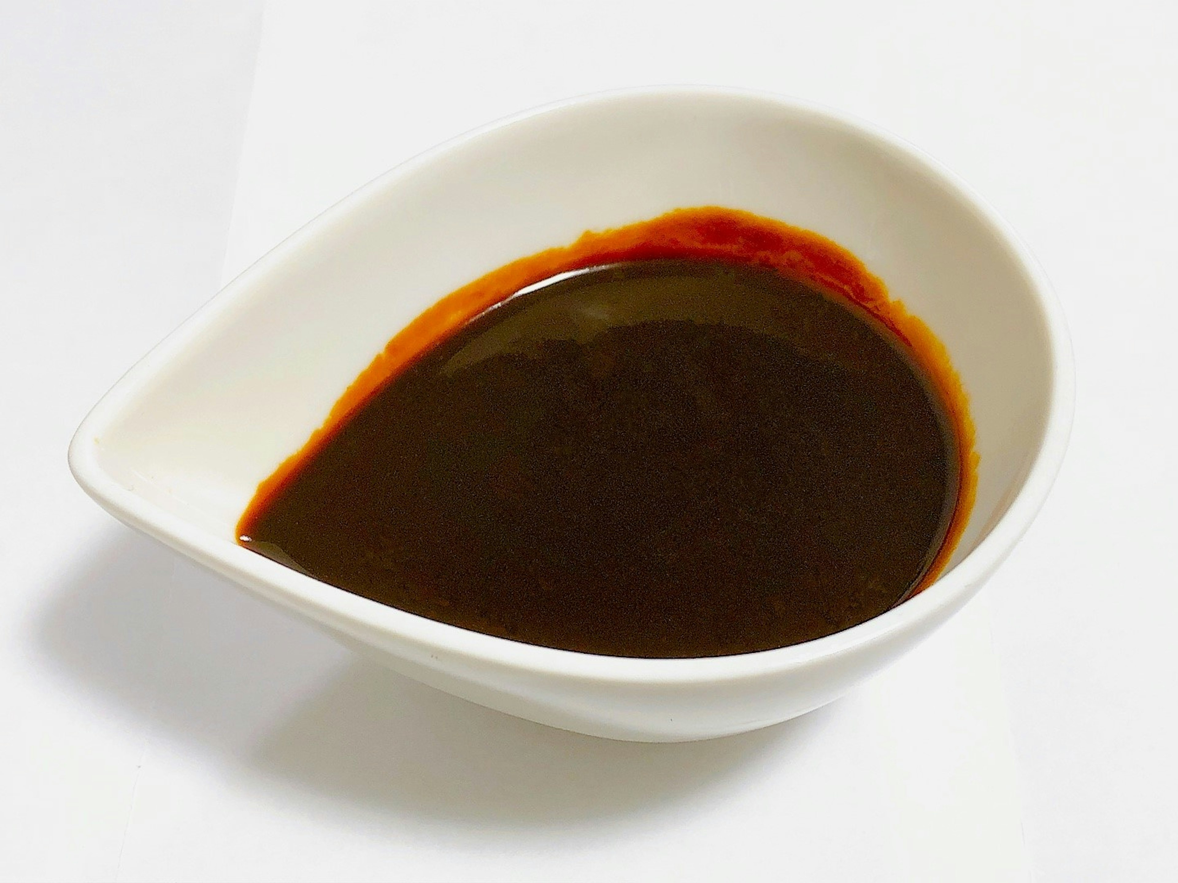 Dark brown sauce in a white dish