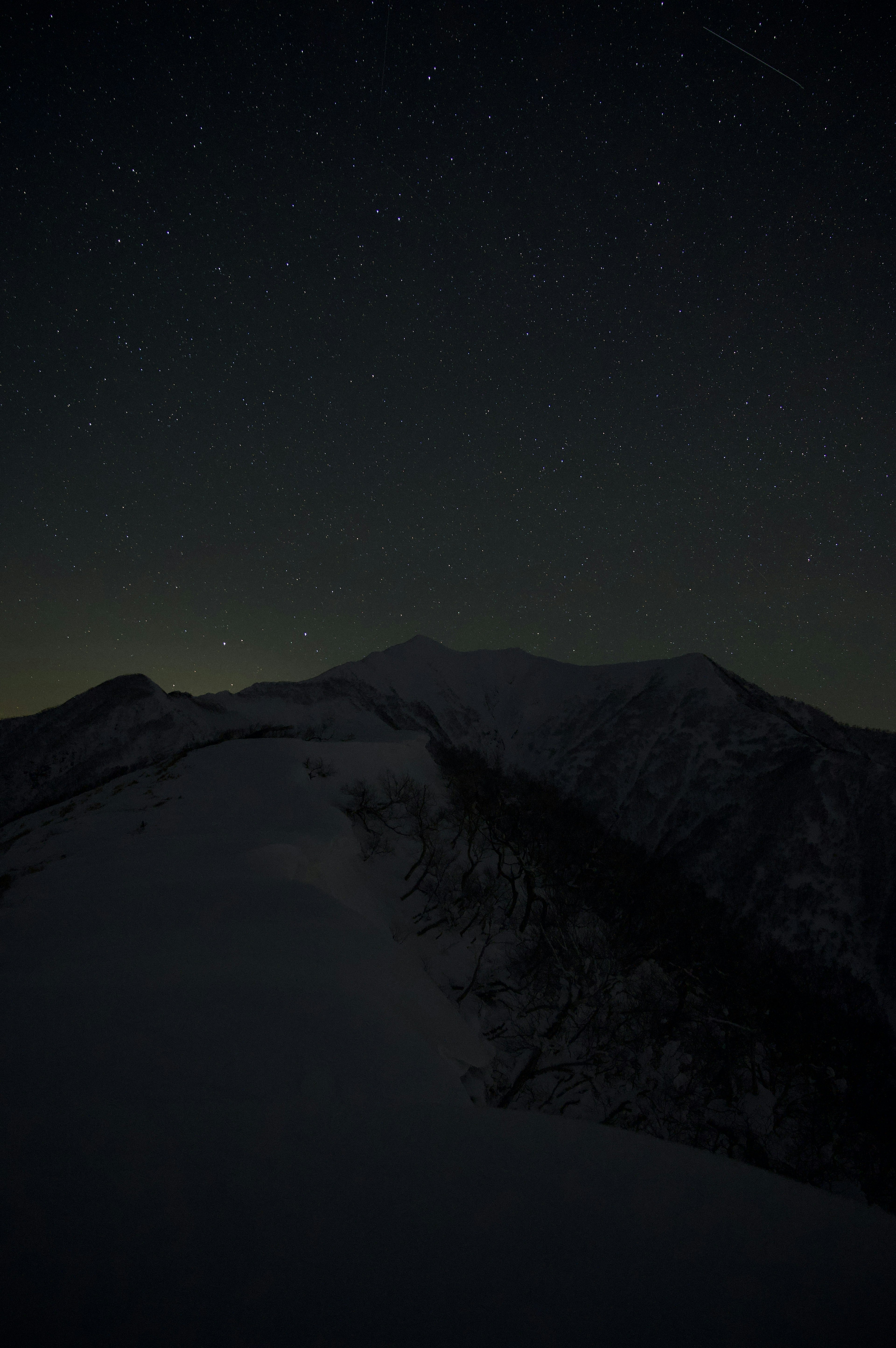 雪に覆われた山の頂上と星空の風景