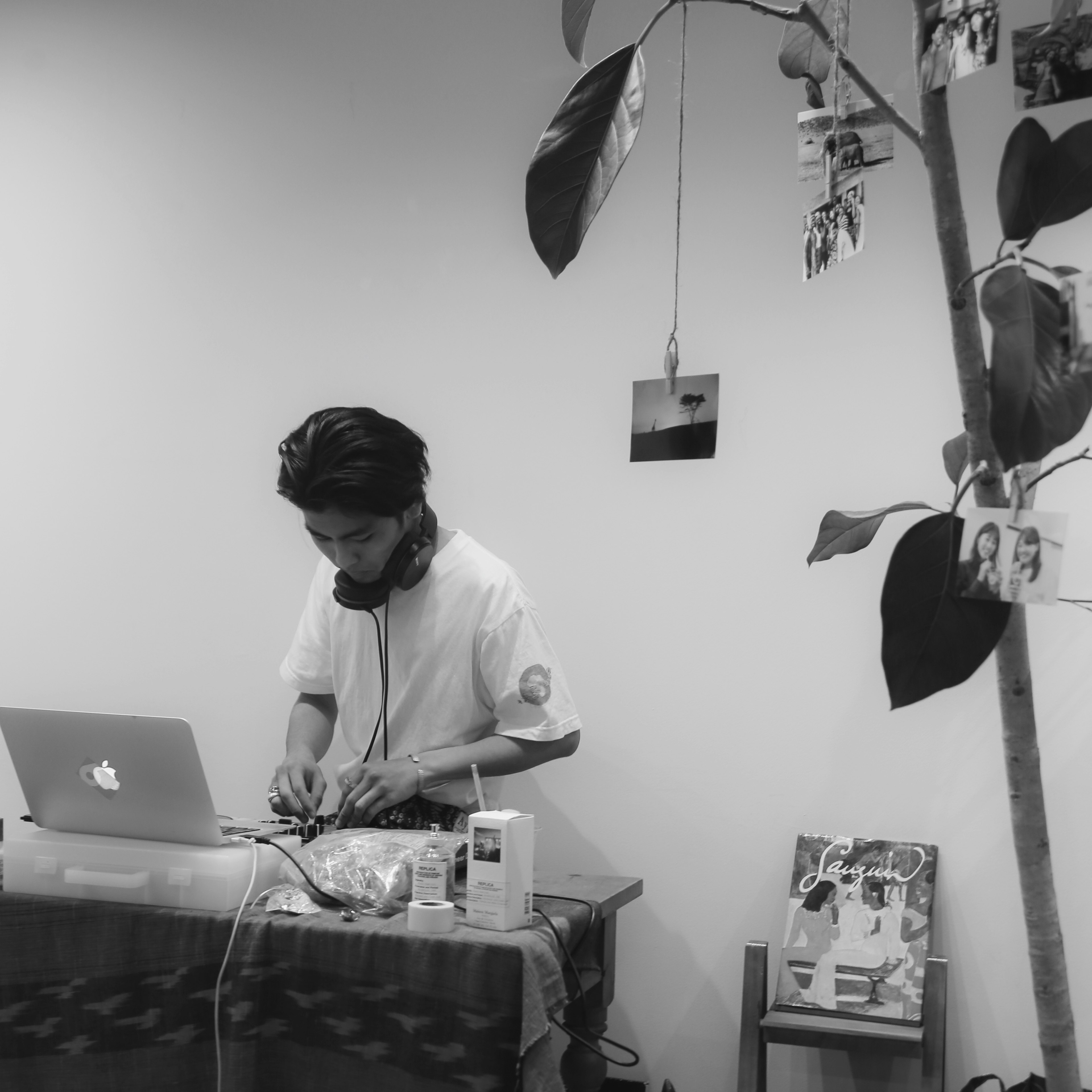 Young man creating music on a laptop in a minimalistic room