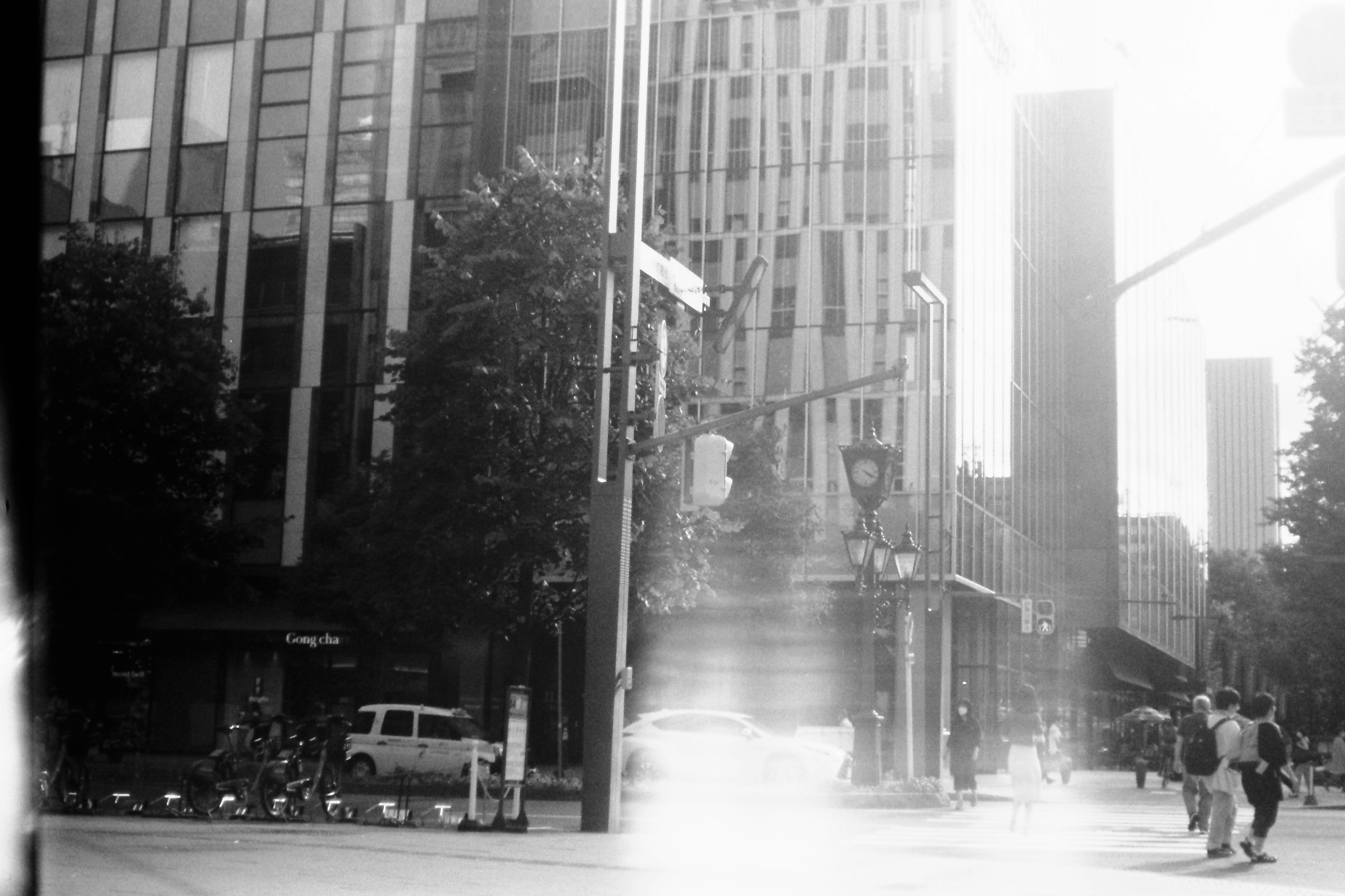 Black and white urban scene with buildings and pedestrians