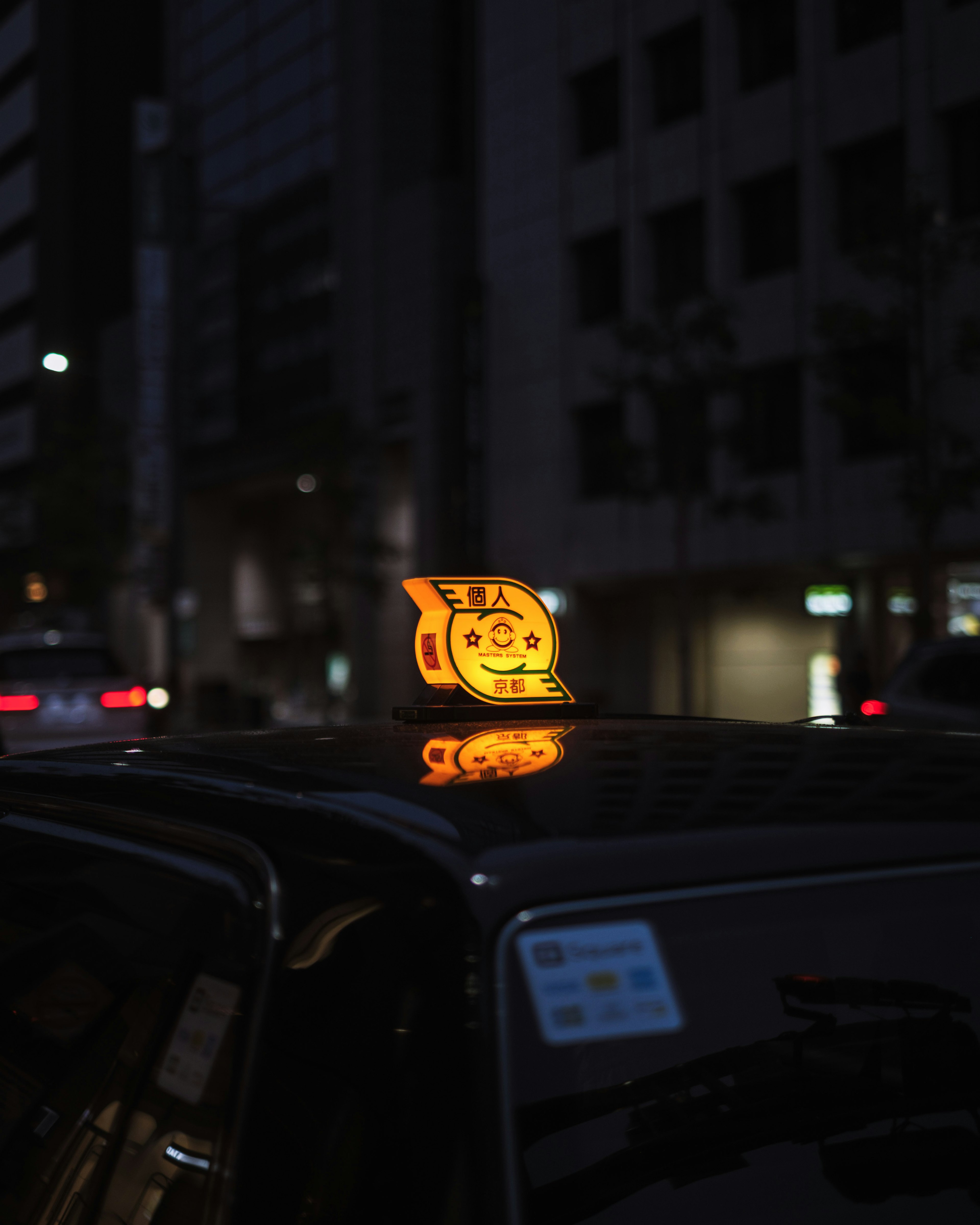 Señal de taxi iluminada en el techo de un coche en una ciudad de noche