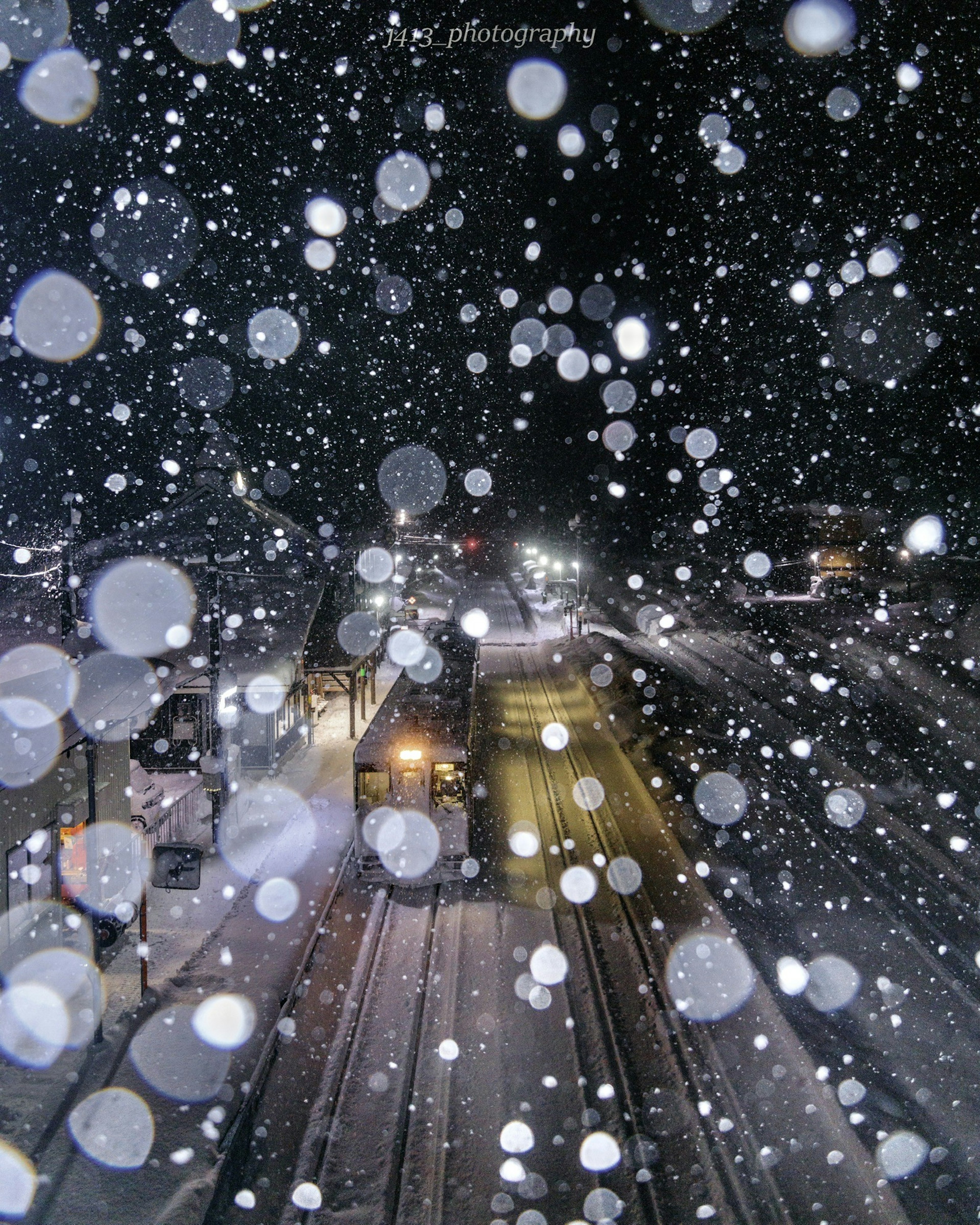 Scène ferroviaire nocturne enneigée avec fond bleu et flocons de neige