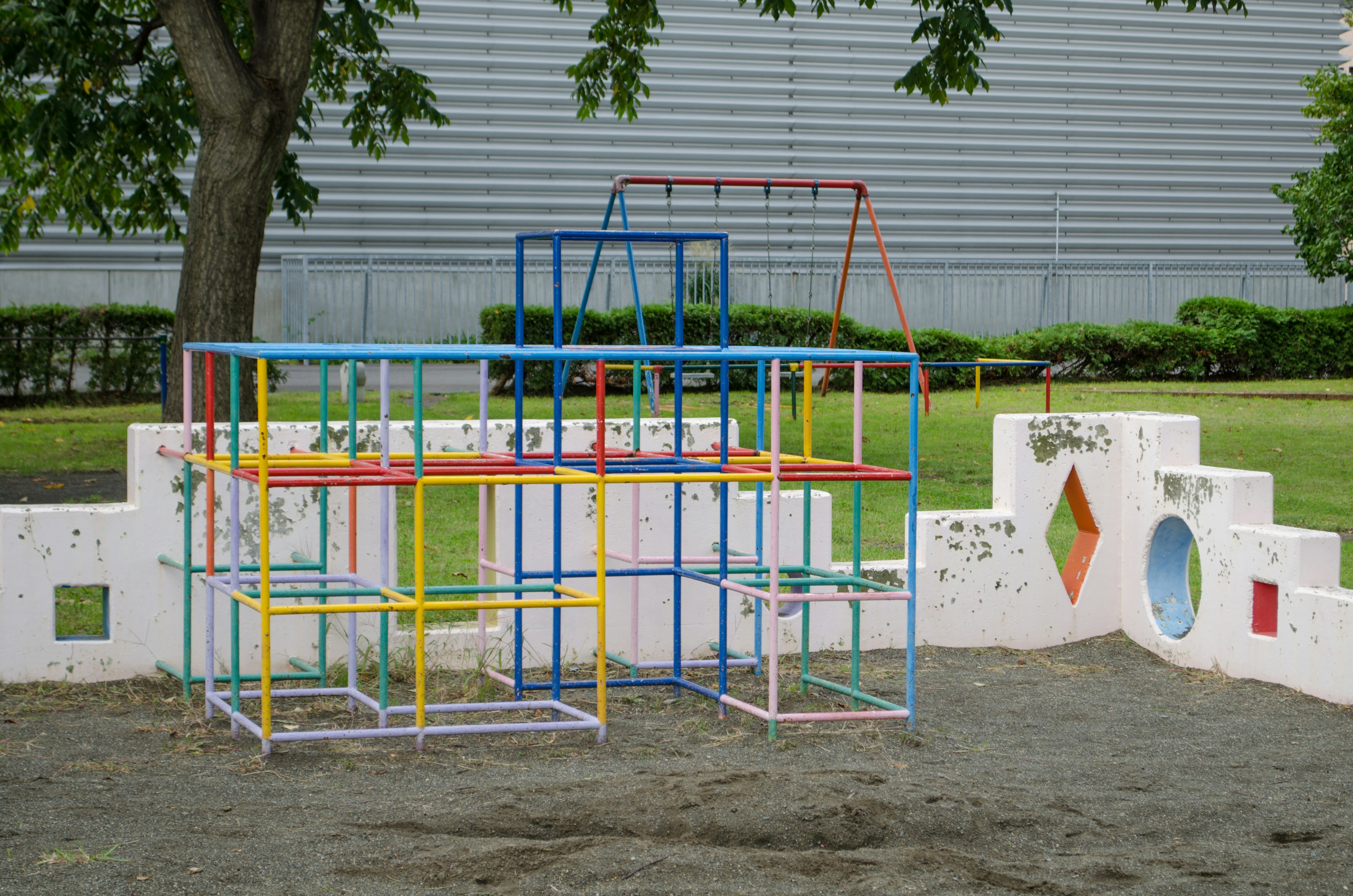 Bunte Spielgeräte in einer Parklandschaft