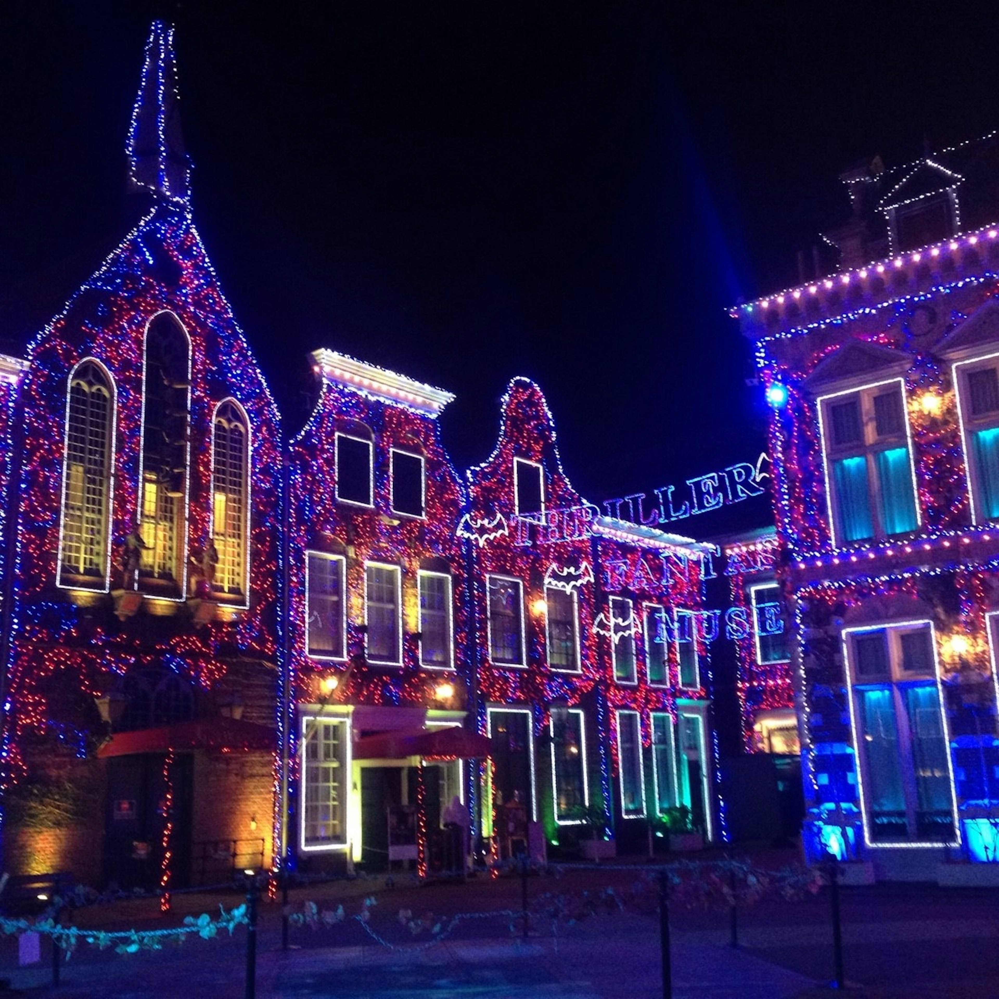 Hermosa vista de edificios adornados con luces coloridas por la noche