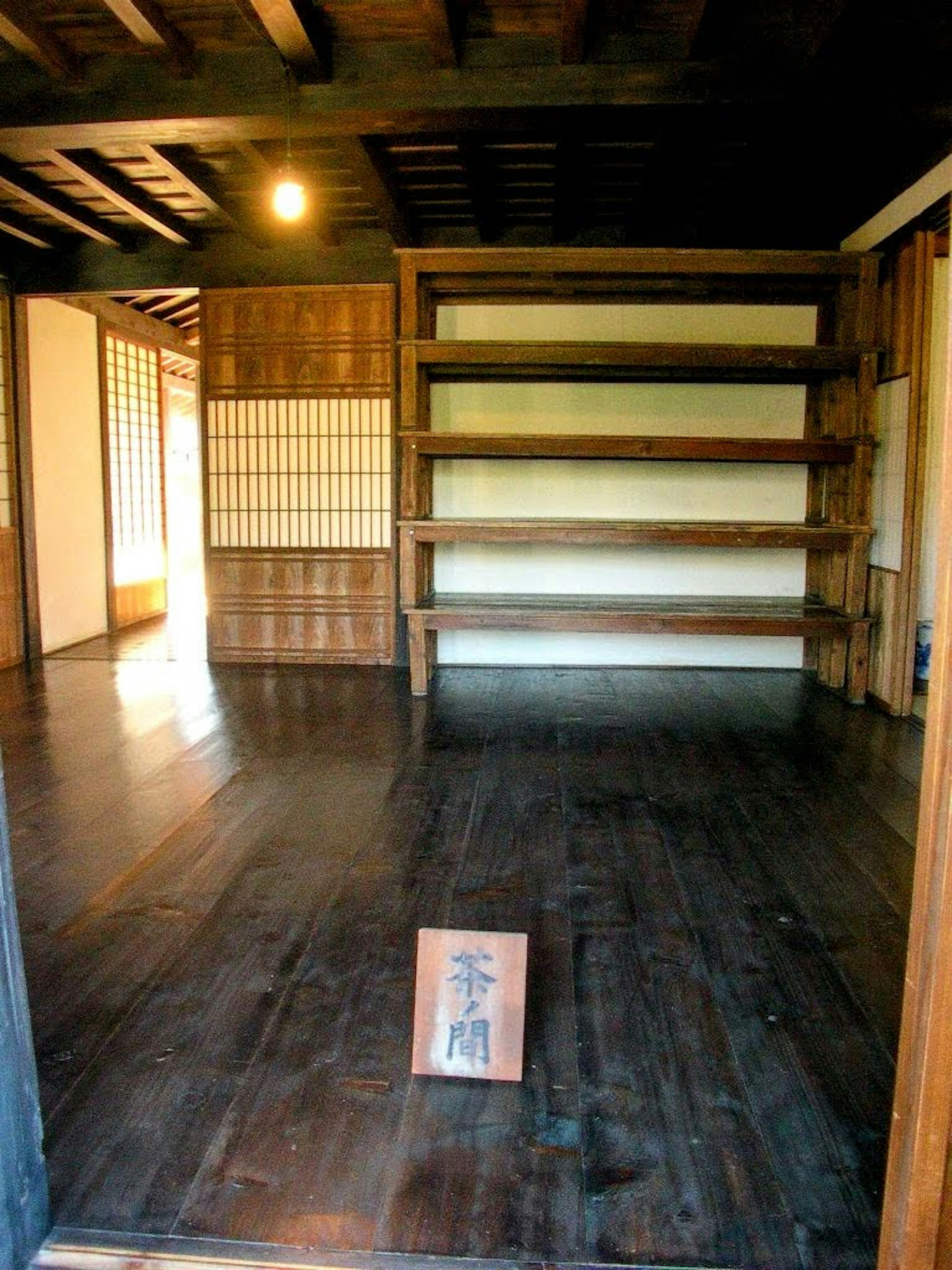 Interior of a traditional Japanese room with wooden floor and shelves featuring soft lighting