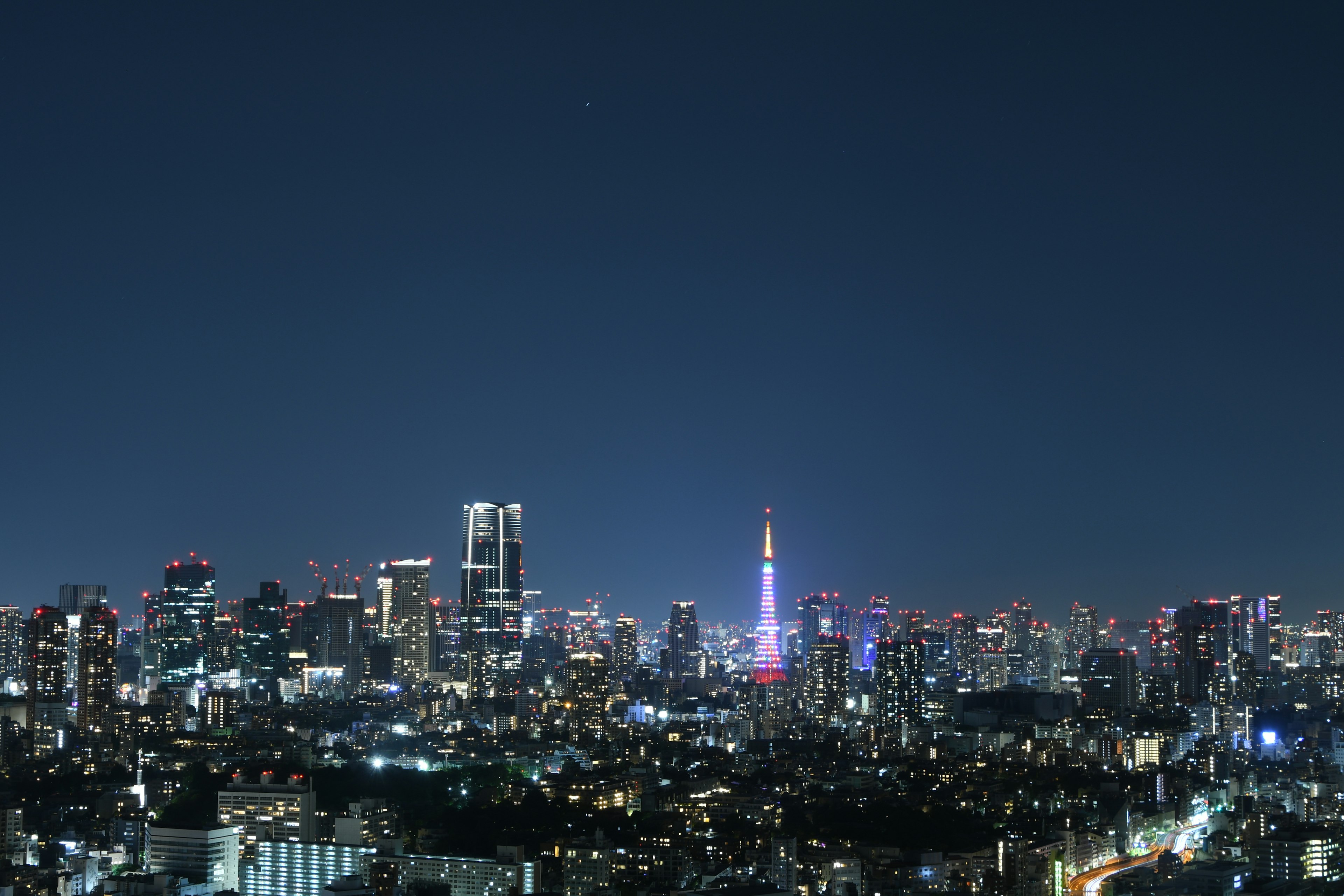 Pemandangan malam Tokyo dengan gedung pencakar langit dan Menara Tokyo yang diterangi