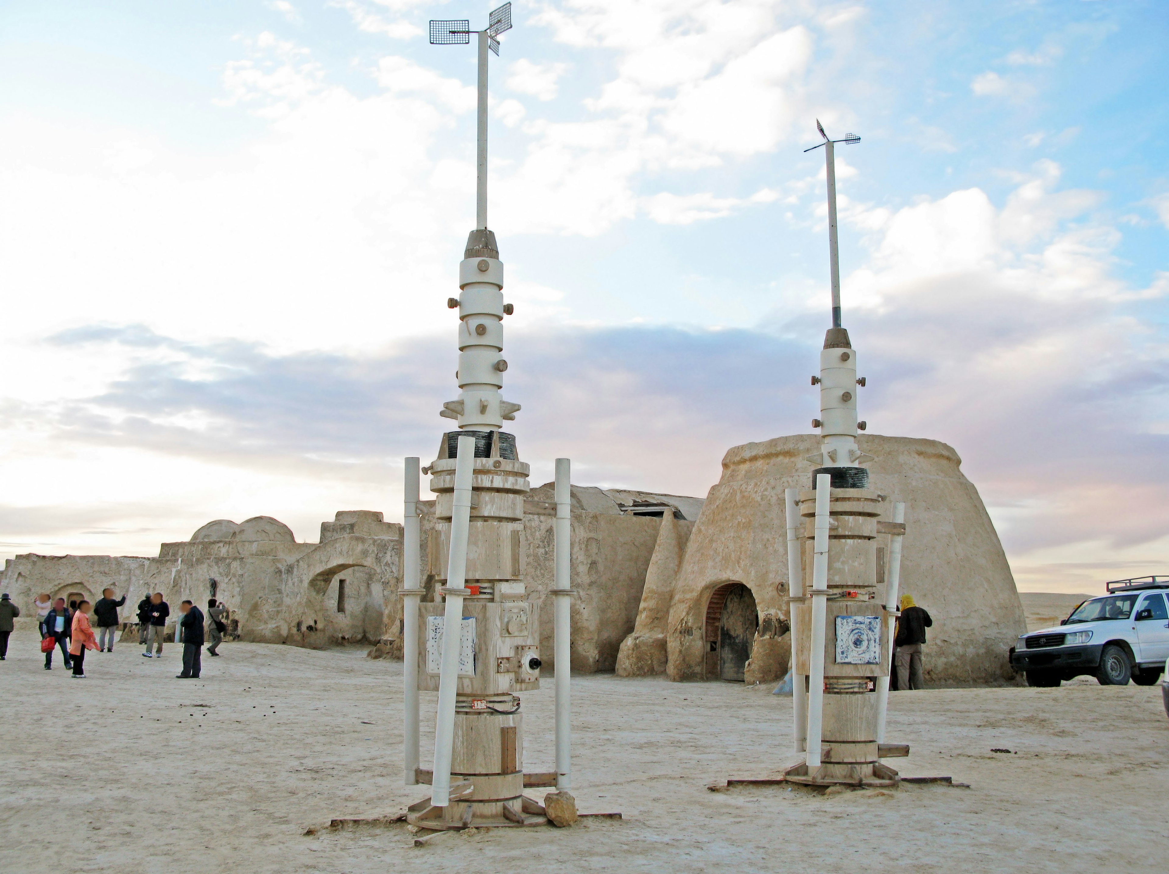 Wind turbines and an ancient structure in a desert landscape