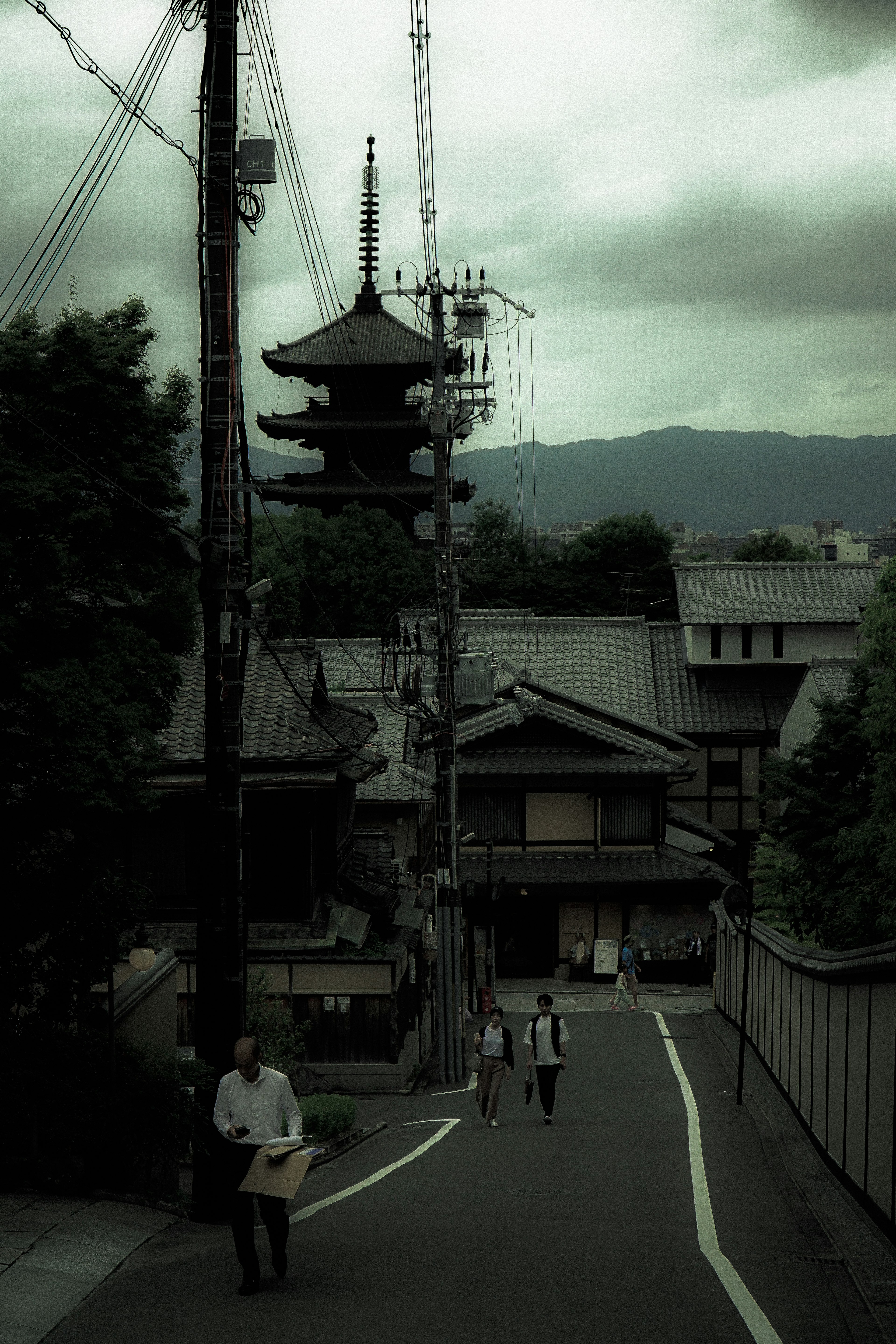 古い日本の街並みと寺の塔が見える風景