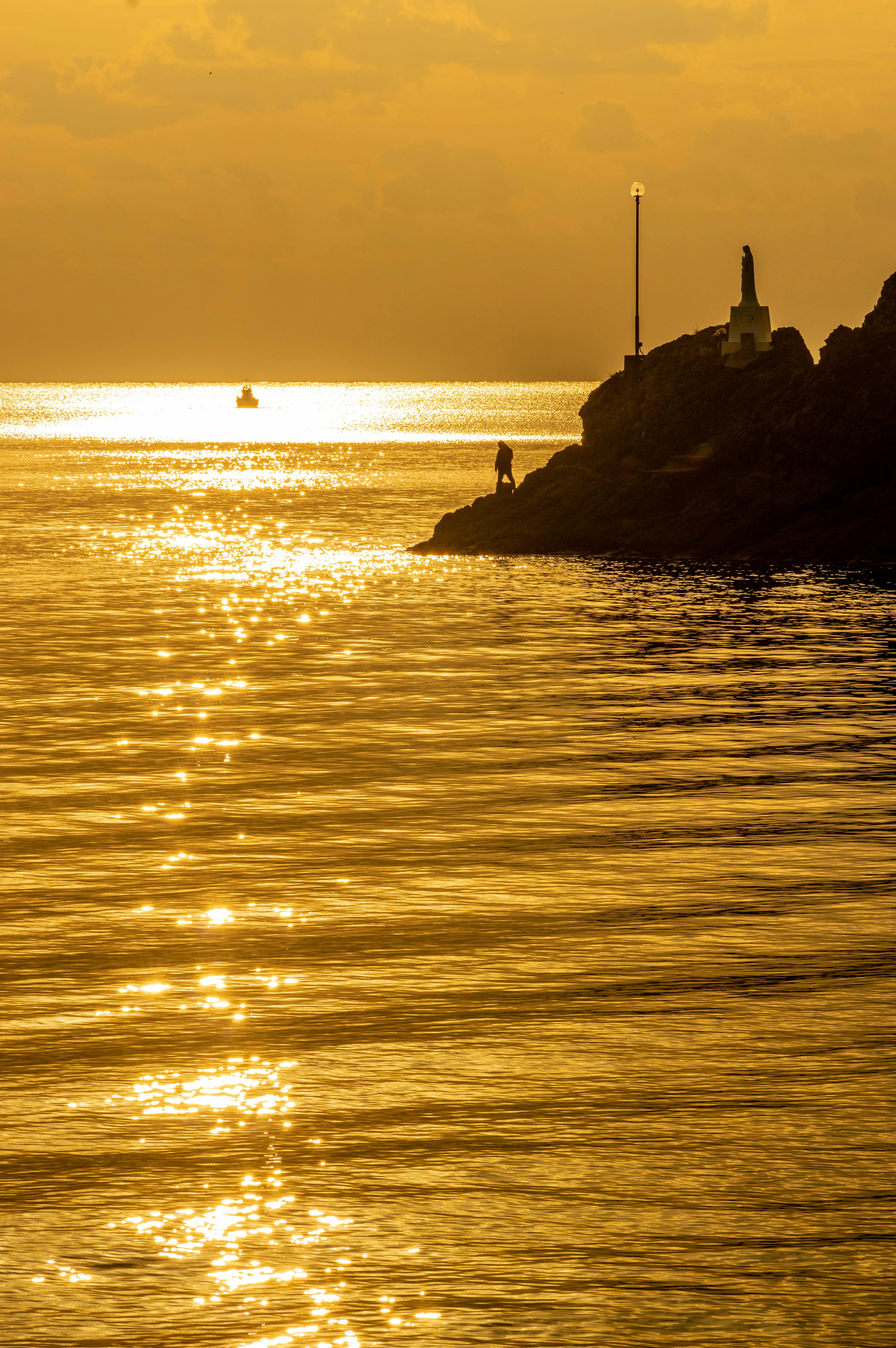 Scena di tramonto costiero con acqua scintillante e una piccola barca