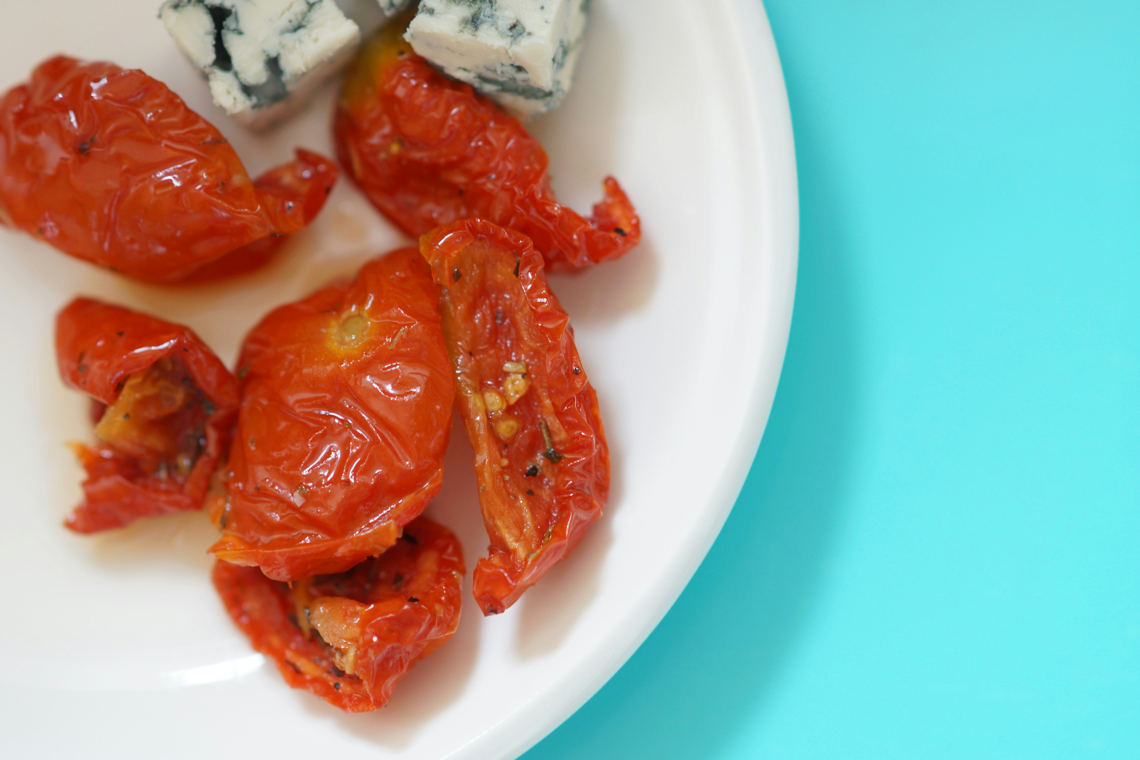 Pomodori secchi e formaggio blu su un piatto bianco