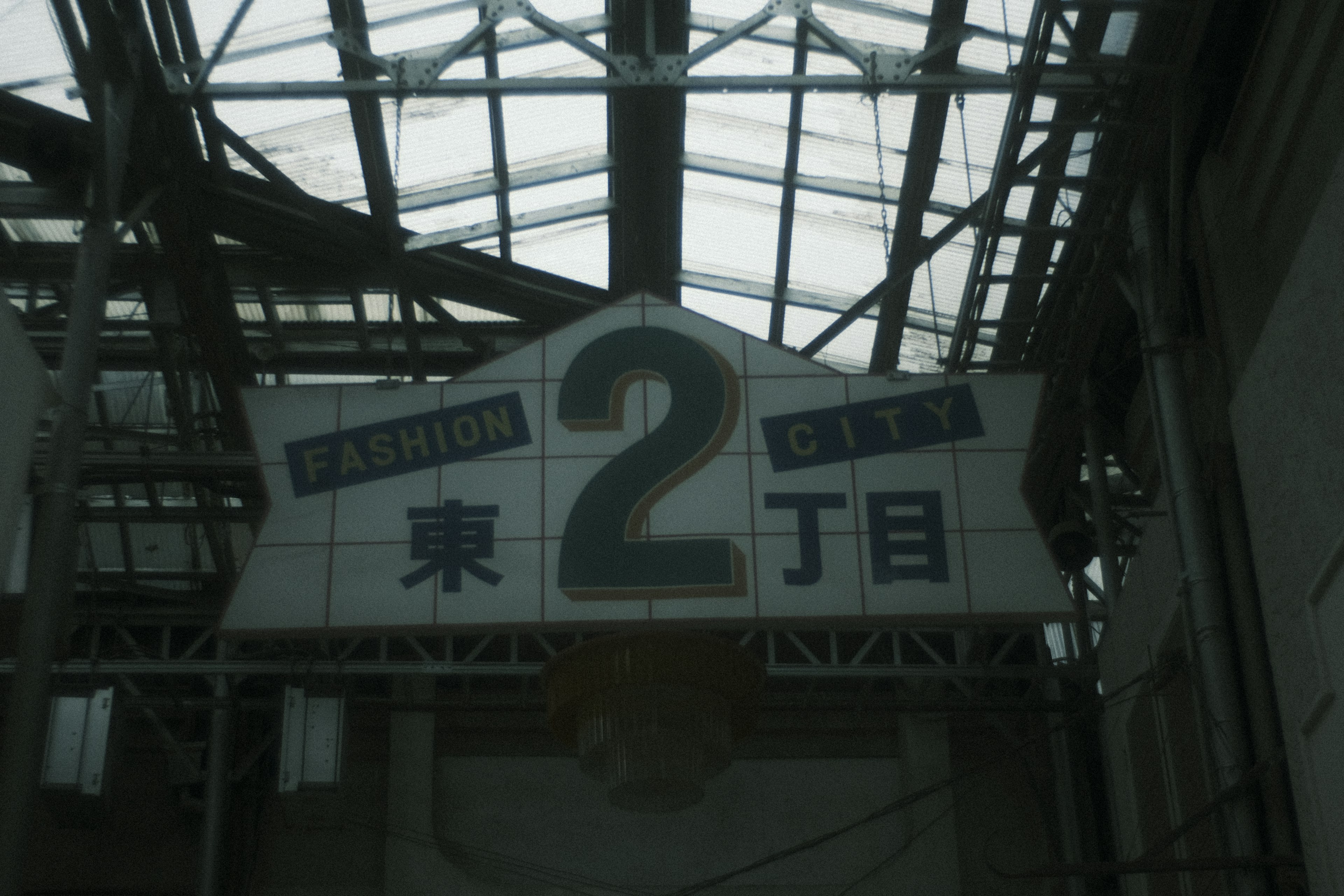 Sign in a covered market displaying the number 2 and the characters for East