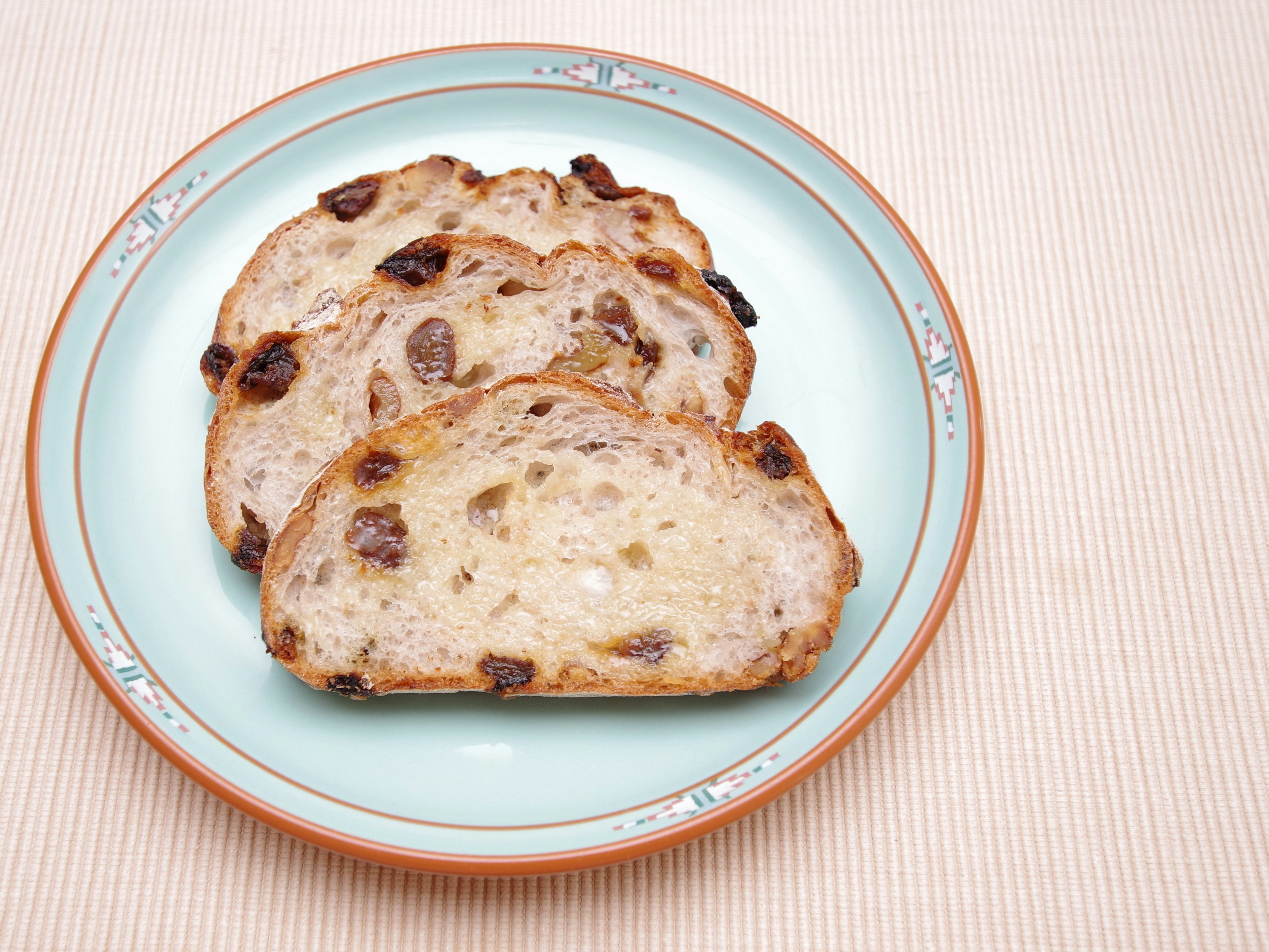 Pain aux raisins tranché sur une assiette bleu clair