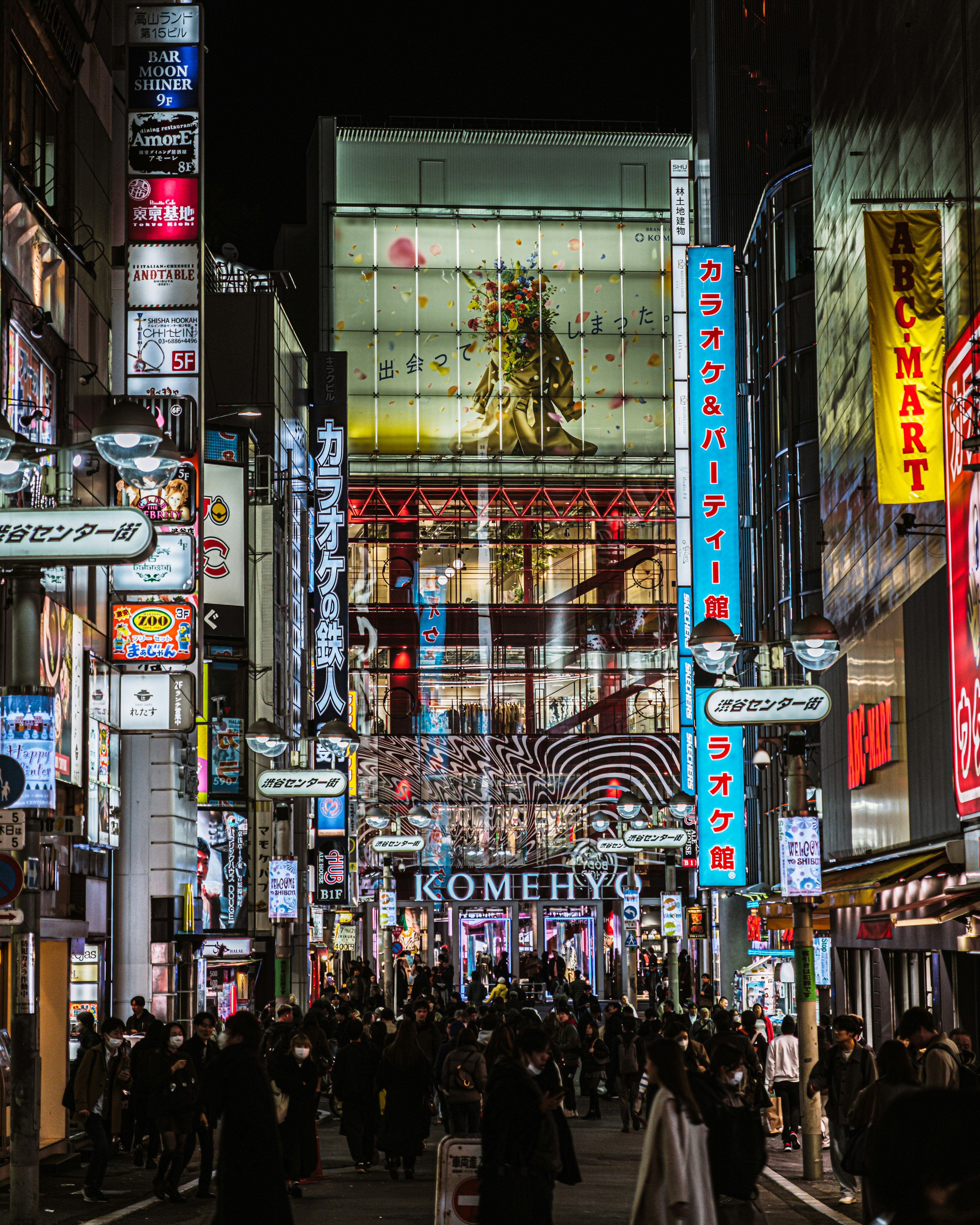 Bustling nightlife scene with crowds illuminated by neon signs and billboards