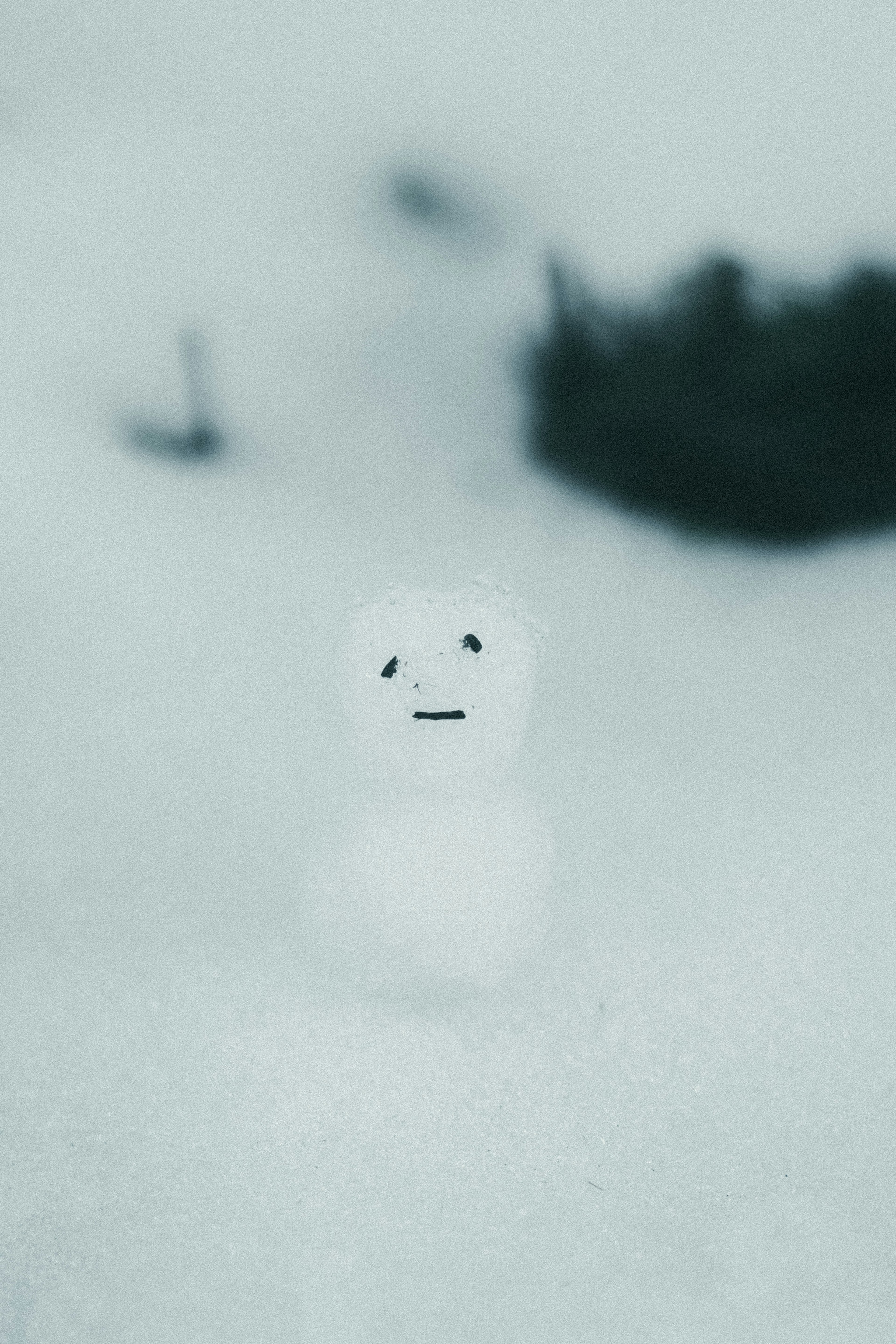 Une petite figurine ressemblant à un bonhomme de neige se tenant dans la neige