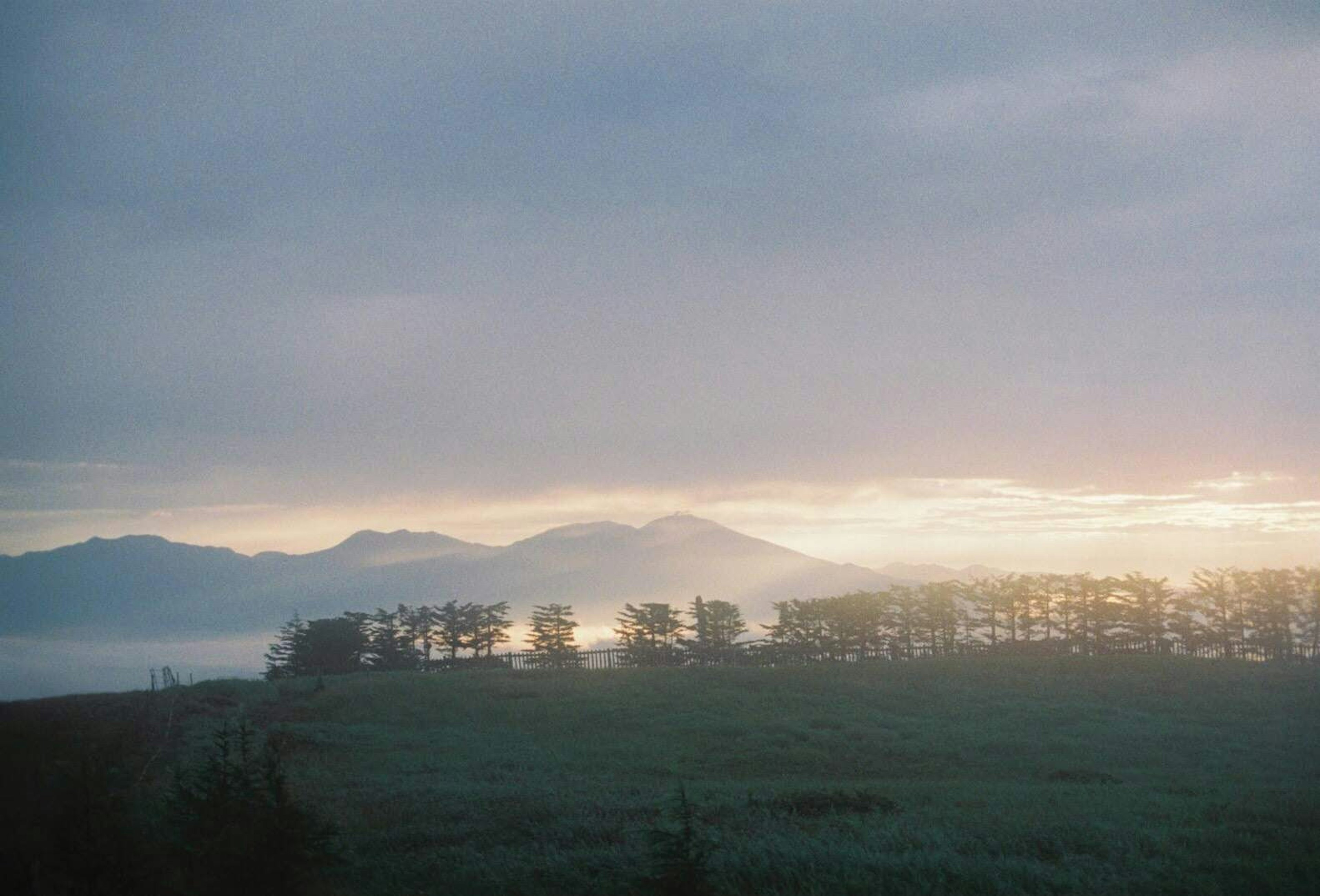 霧の中の山々と柔らかな光の風景