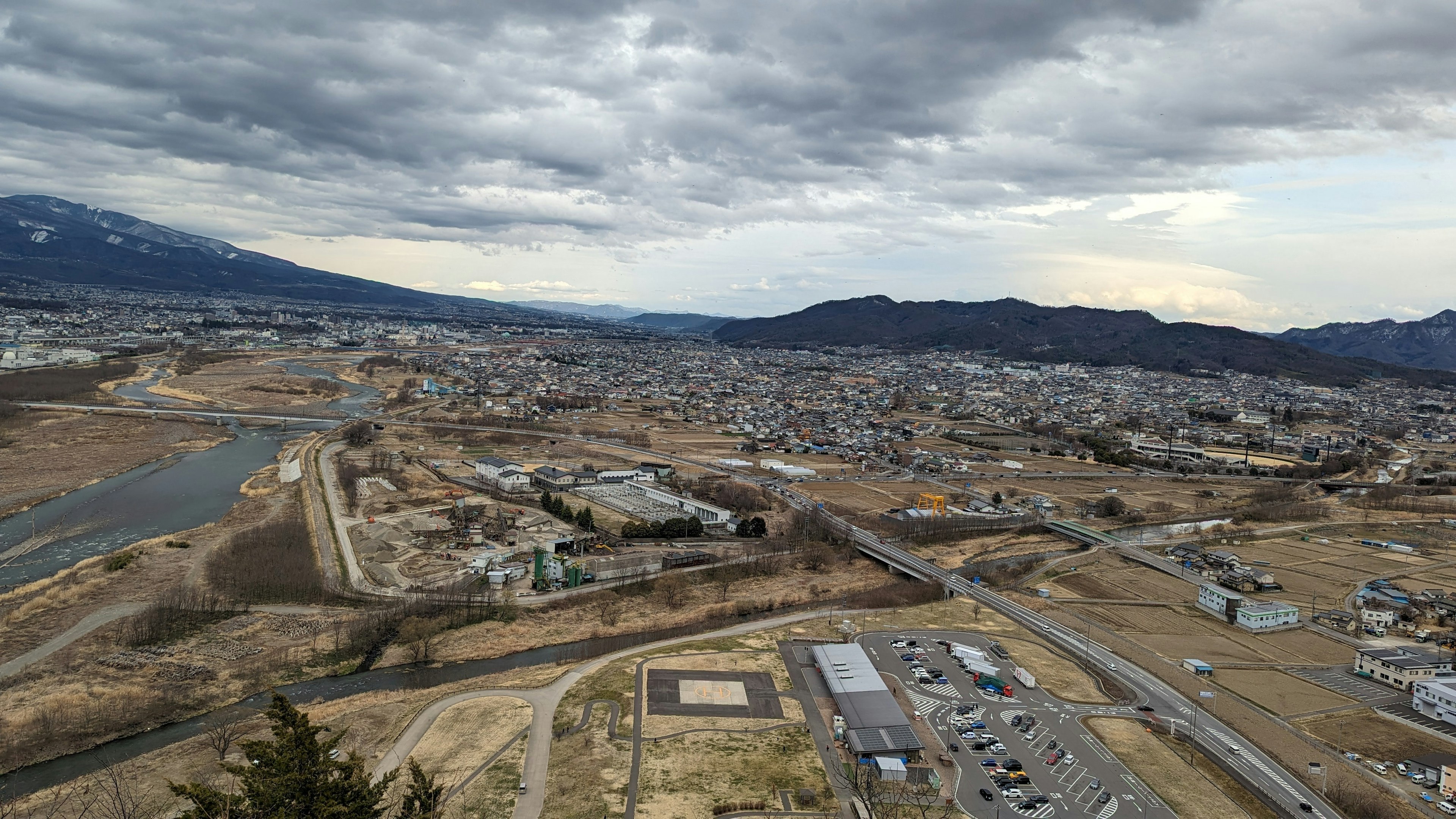 Panoramic view of a town and river with mountains in the background