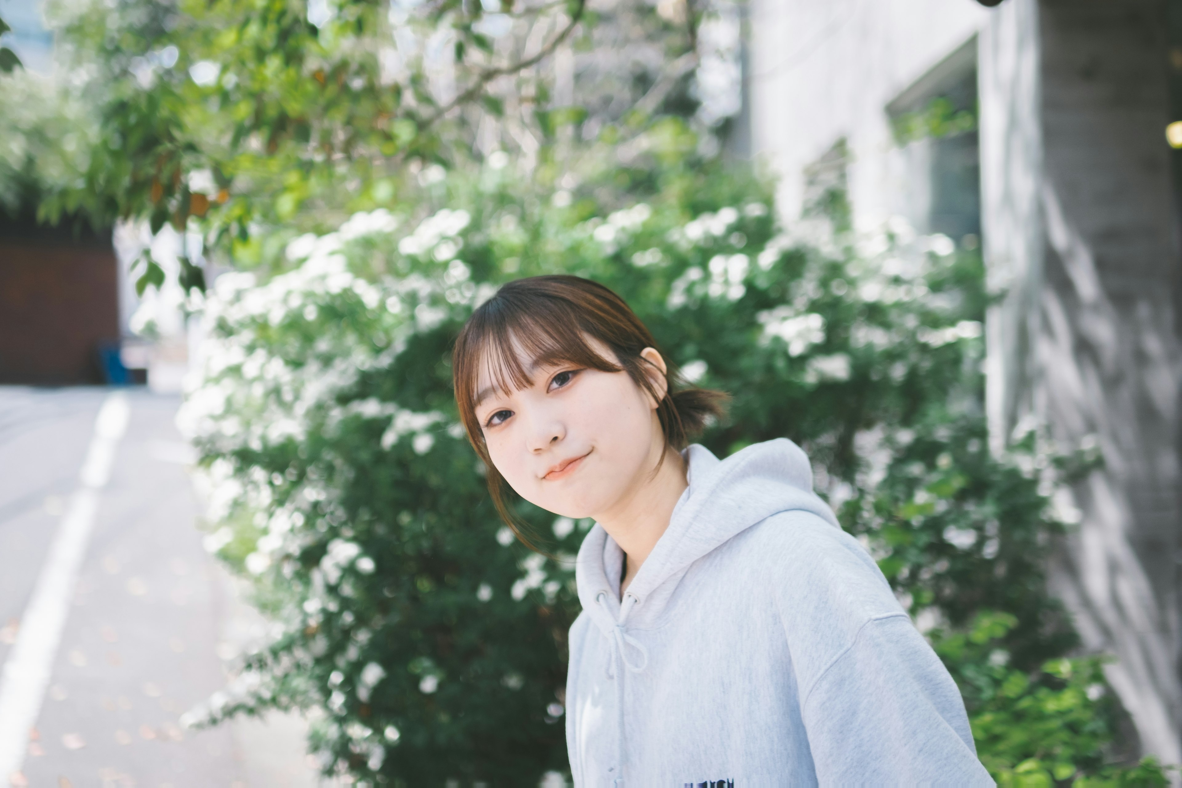 Portrait of a woman standing in front of green plants She is smiling and wearing casual clothing