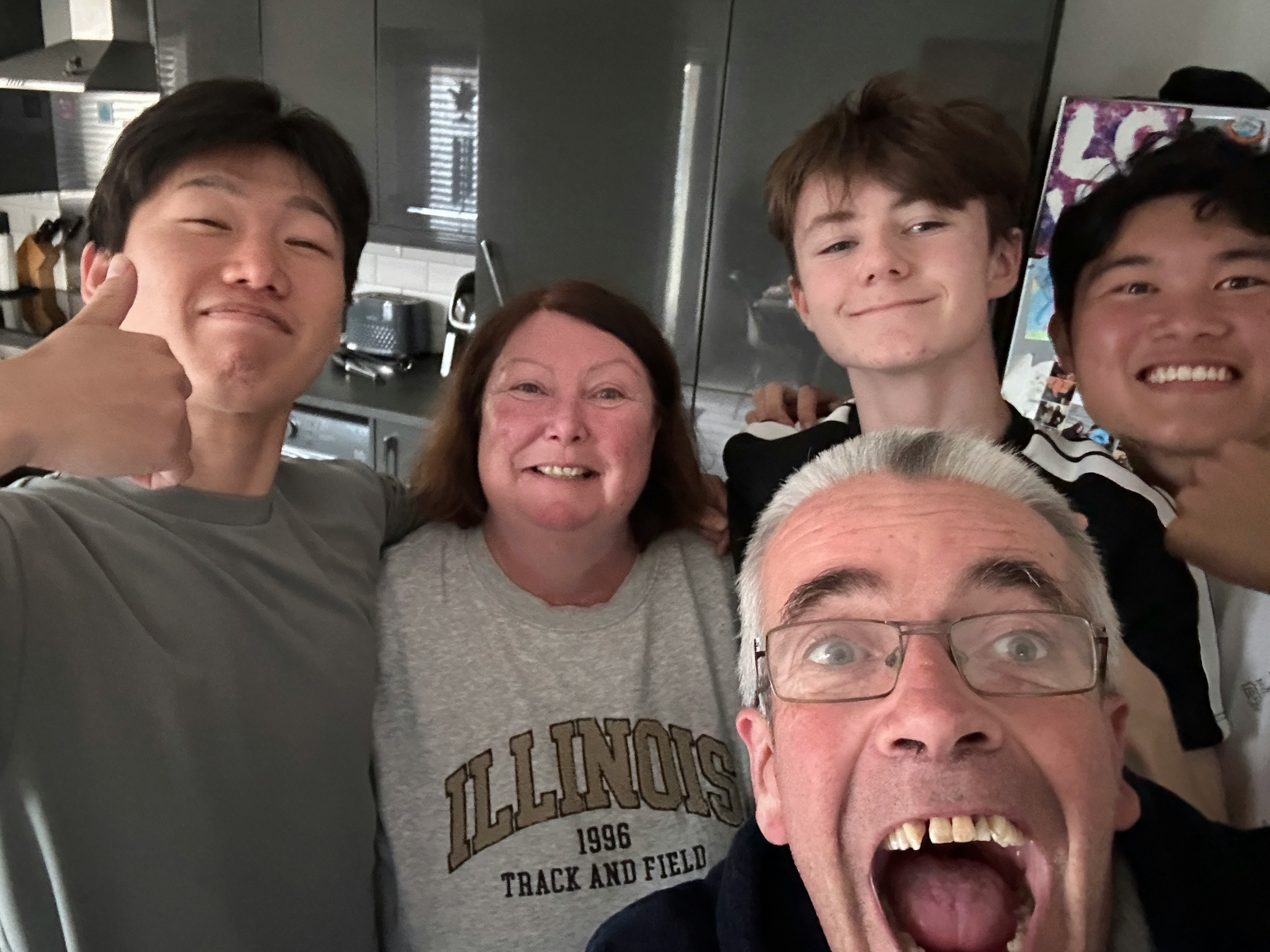 Foto di famiglia sorridente gruppo in una cucina uomo e donna di mezza età due giovani adulti