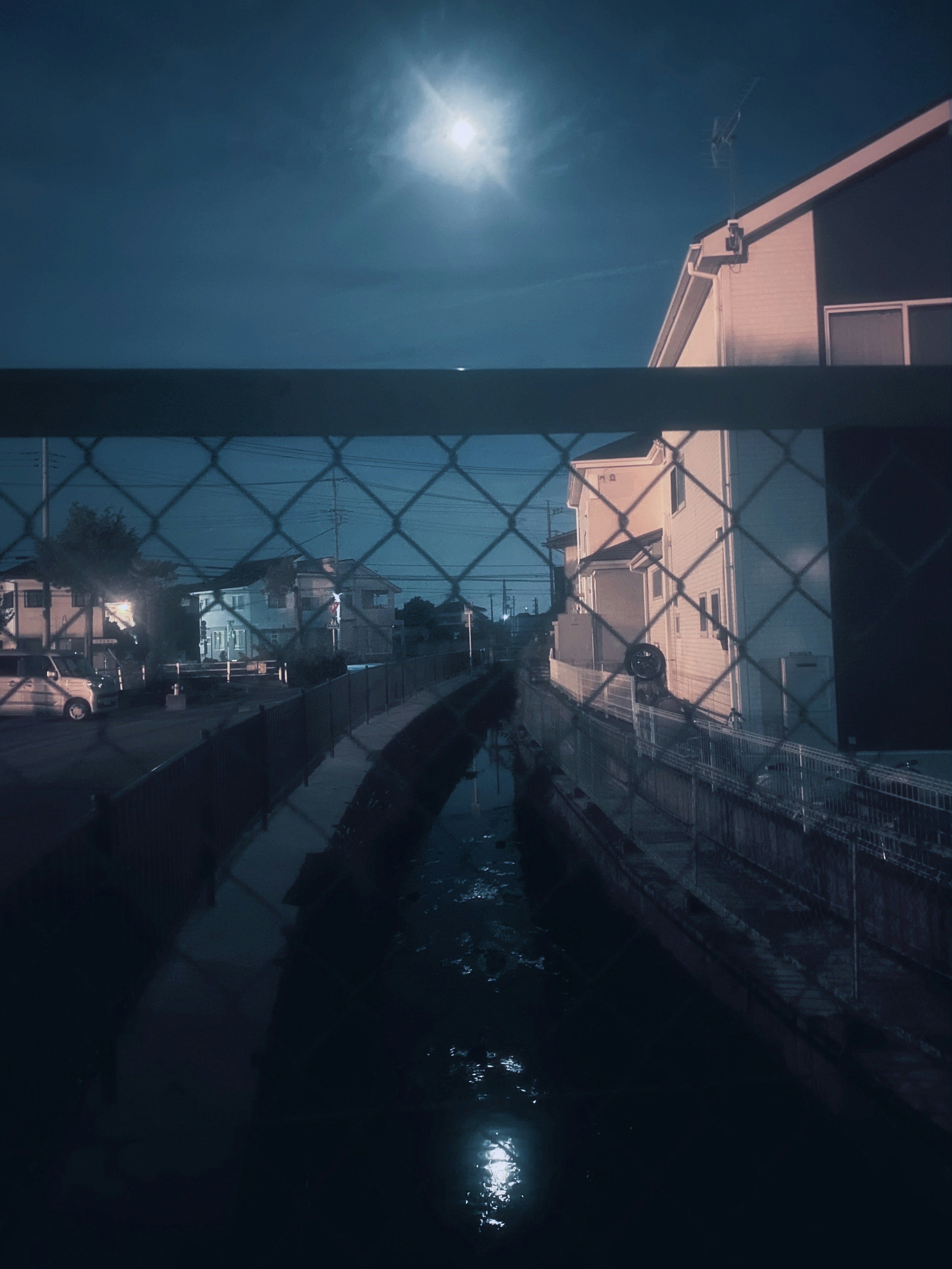 Canal estrecho bajo la luz de la luna con edificios circundantes escena nocturna tranquila