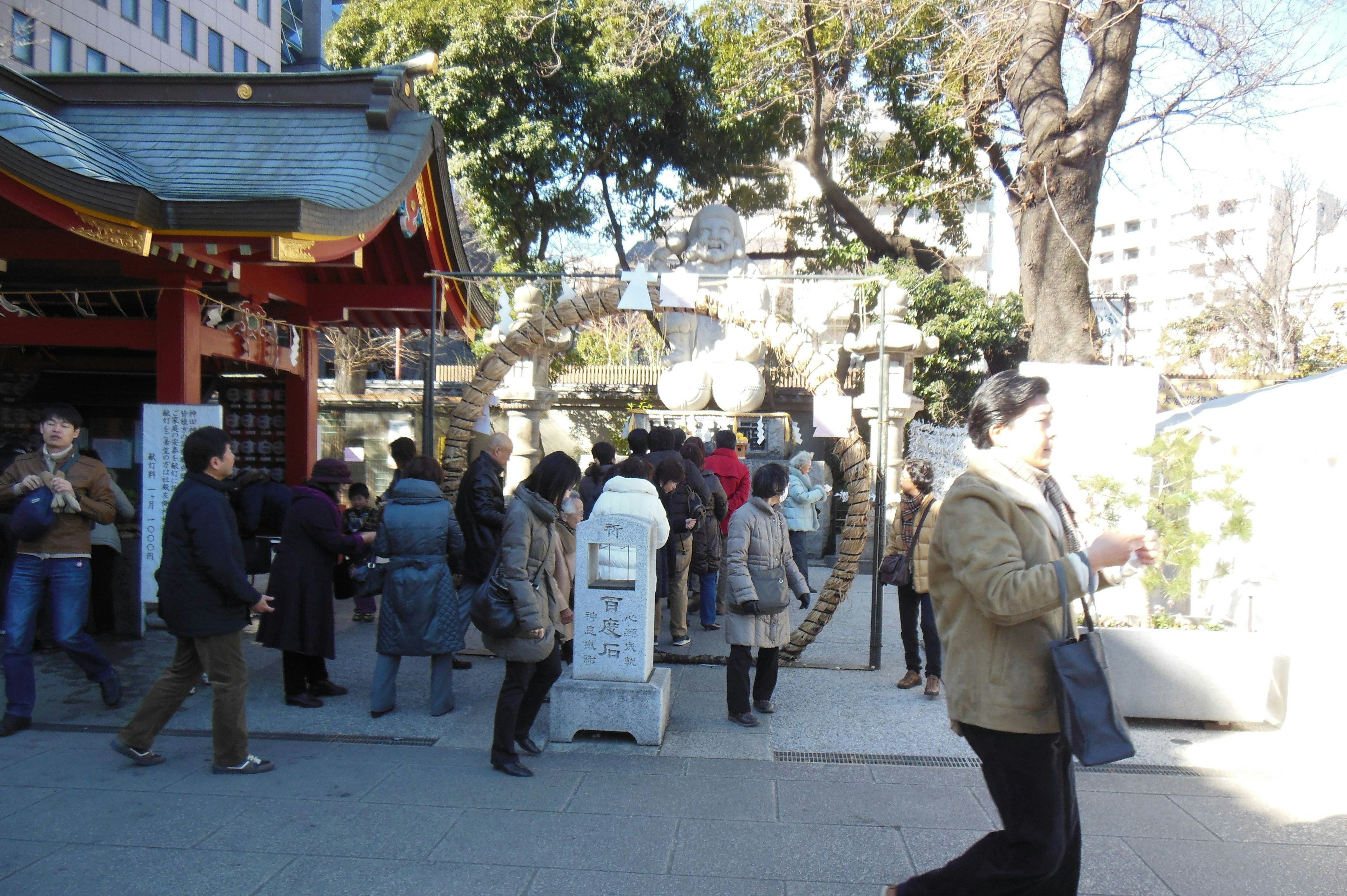 Entrada concurrida de un santuario con personas caminando