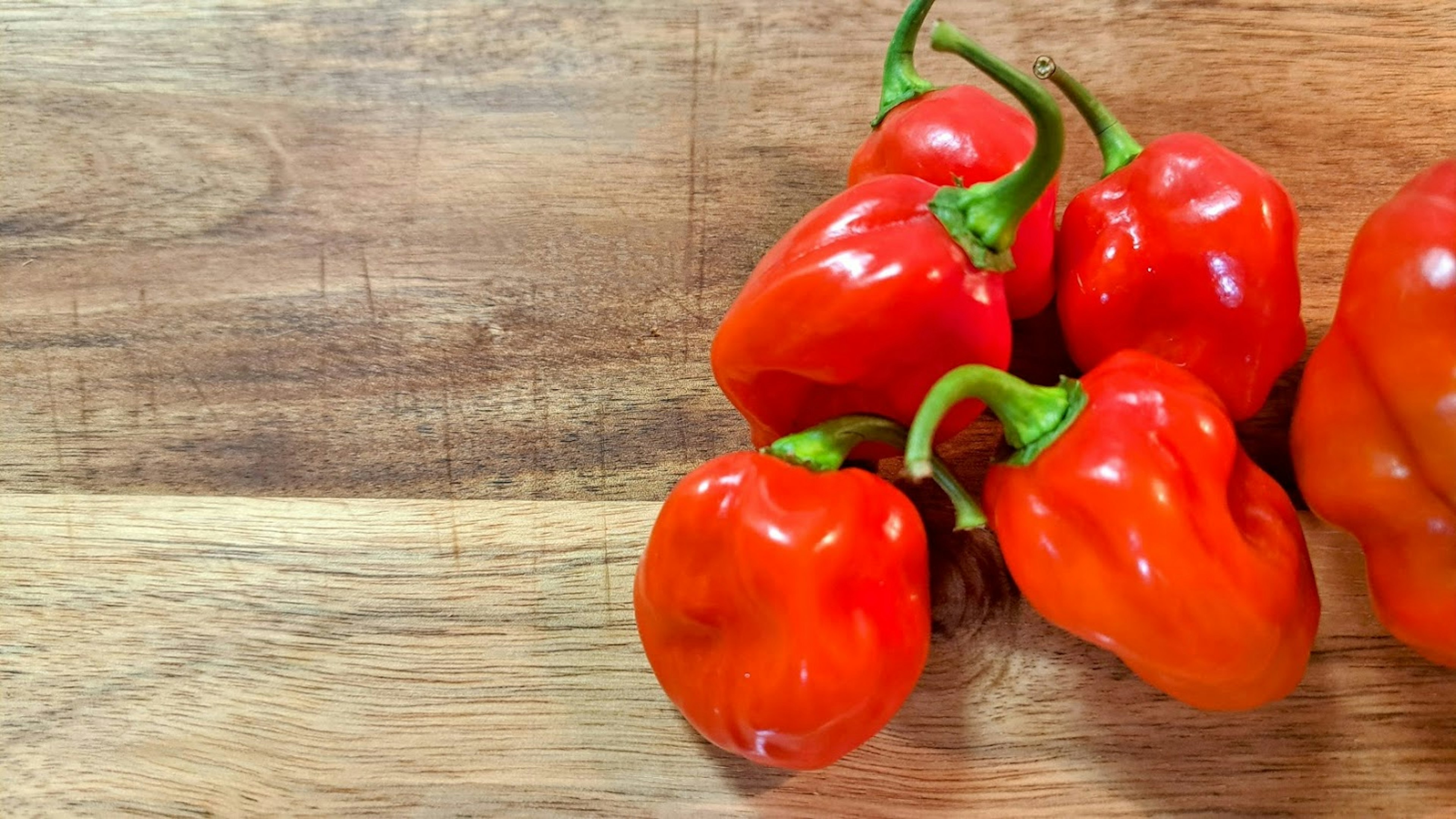 vibrant red peppers placed on a wooden table