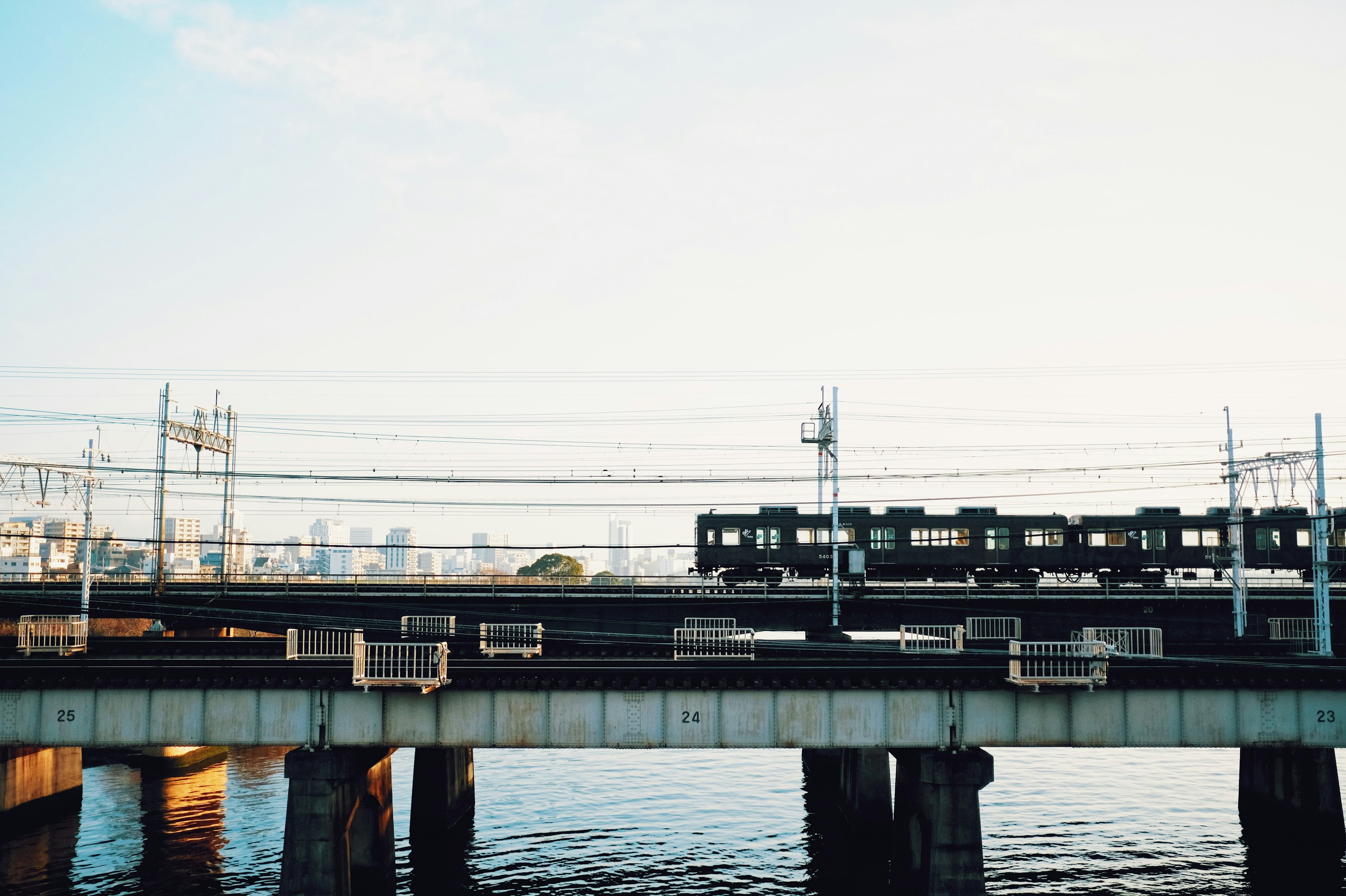 Tren negro que corre sobre un puente sobre el agua